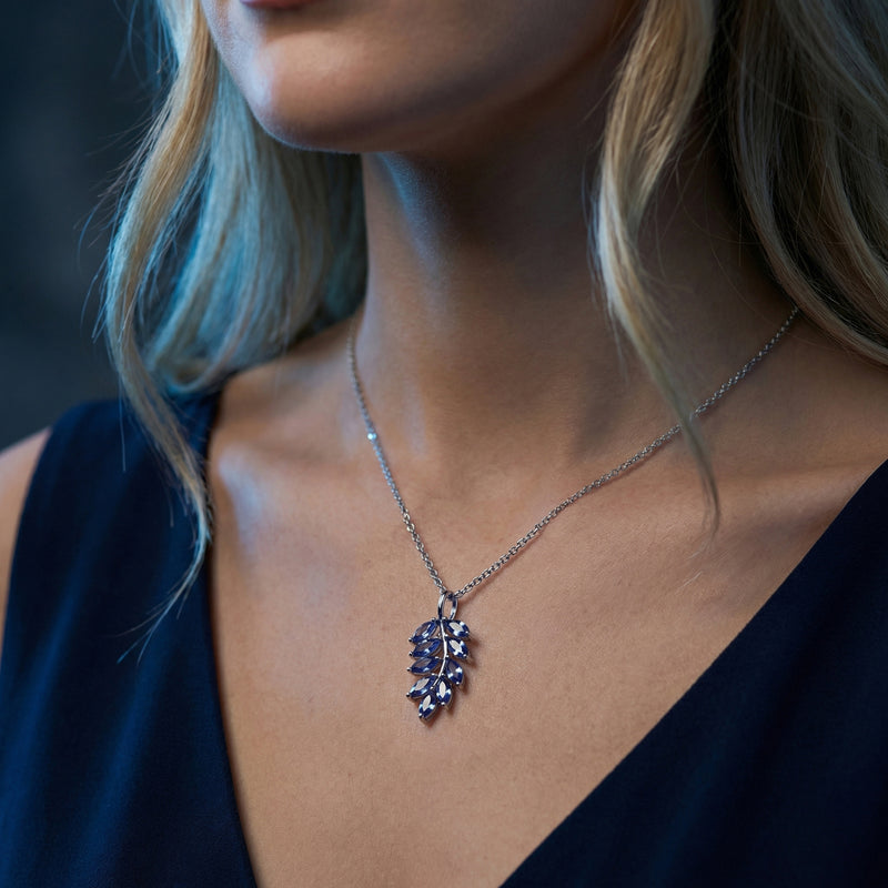 Close-up view of the Laurelia tanzanite marquise cluster necklace in white gold worn by a model.