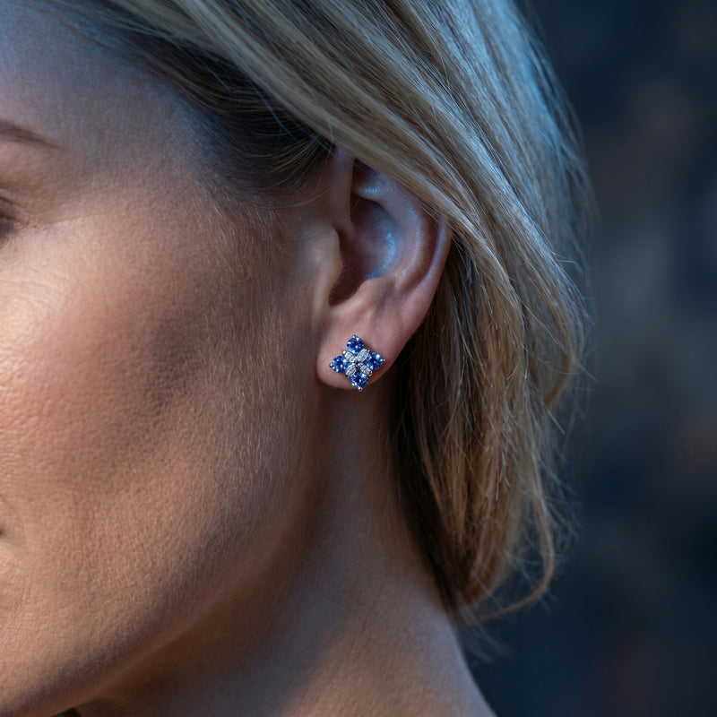 The Lyssandra tanzanite flower cluster earring in silver worn on a woman's ear.