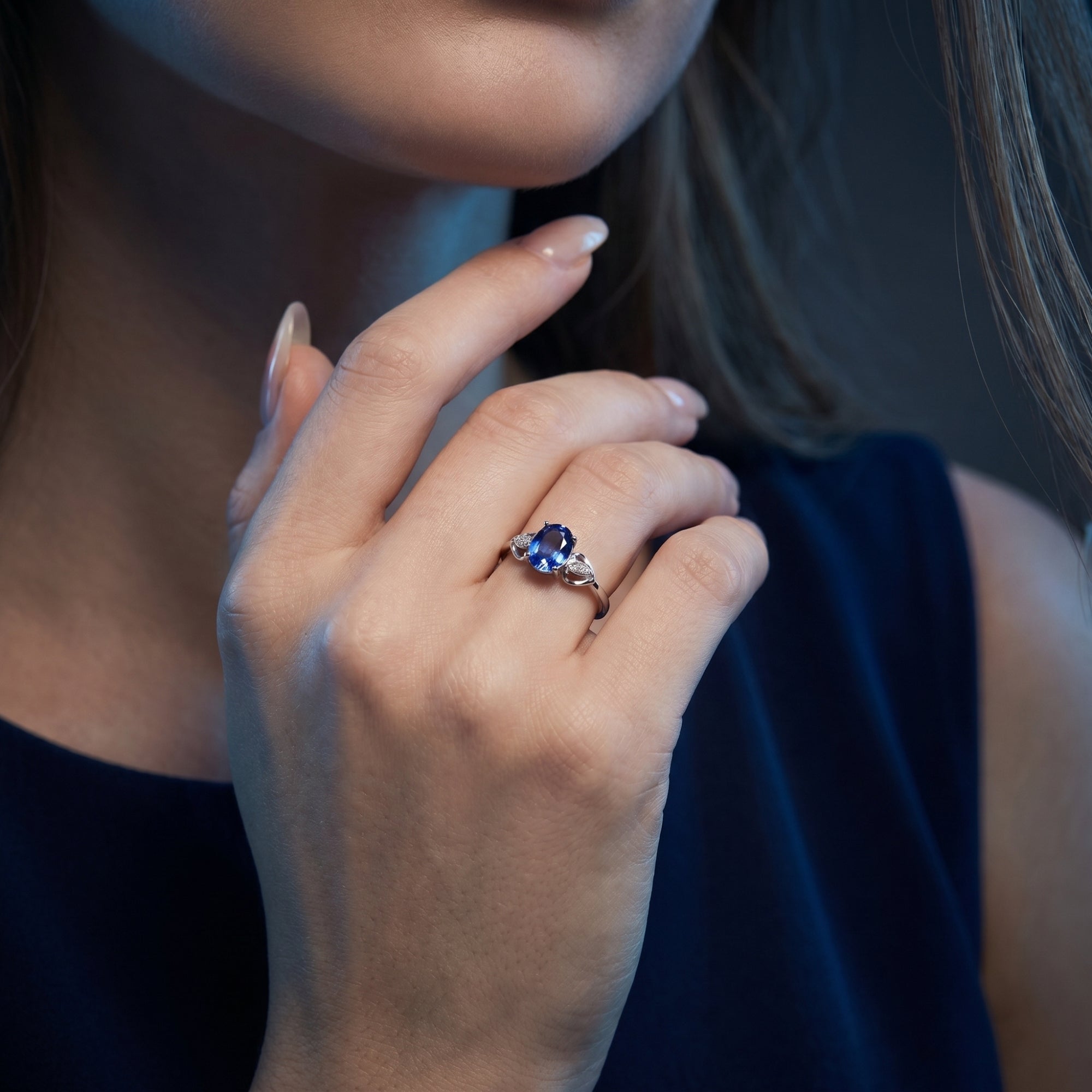 Model wearing the Elysienne oval tanzanite and diamond ring in 18K white gold on her finger.