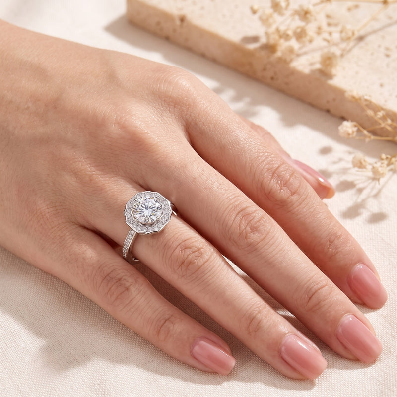 Top-down view of the silver scalloped halo ring worn on a hand.