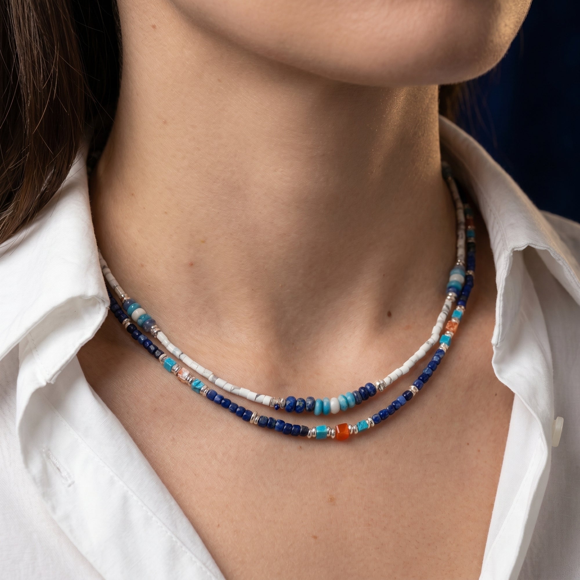 Model wearing the layered Altair natural lapis lazuli bead necklace with silver-toned spacers.