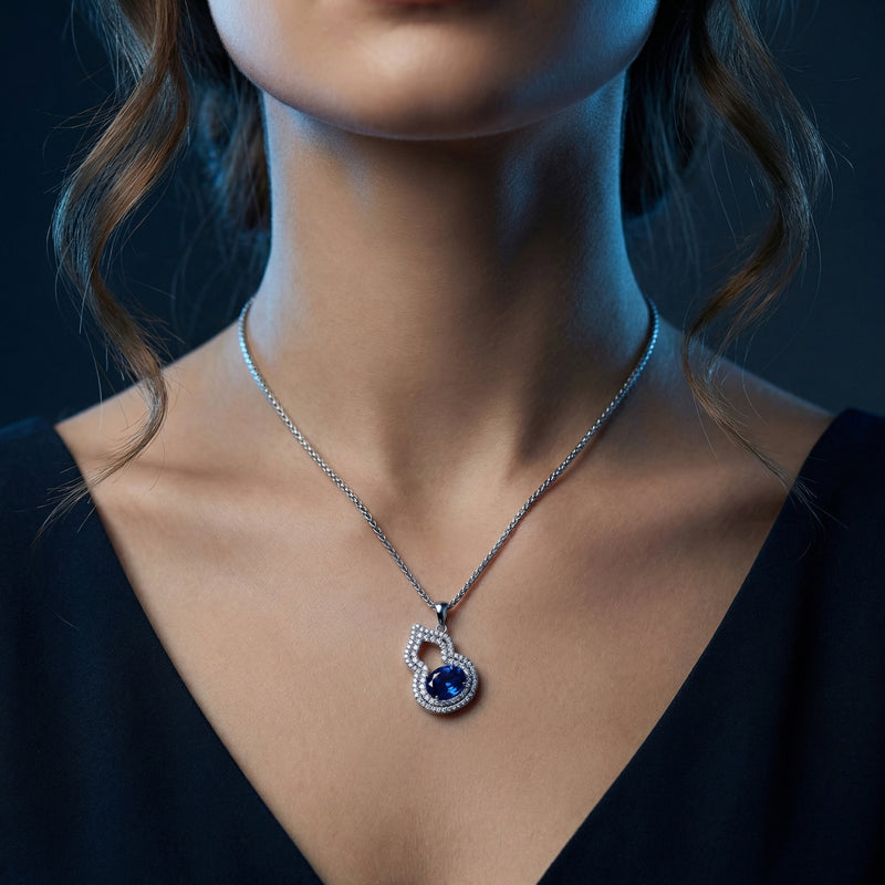 Model wearing the Olyndia natural tanzanite gourd pendant necklace in white gold on a silver chain.