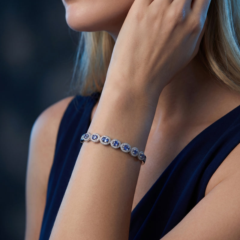 Woman wearing the sterling silver natural tanzanite bracelet with mixed cut stones on her wrist.