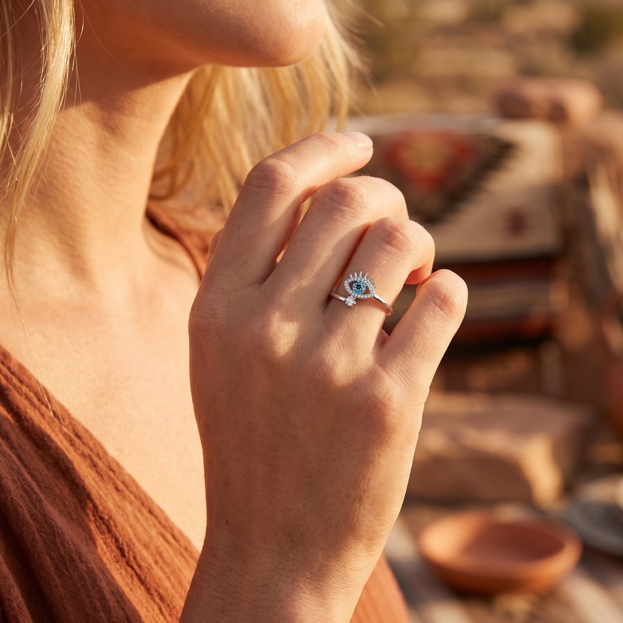 Southwestern-inspired silver turquoise evil eye ring worn by a model in a warm desert environment.