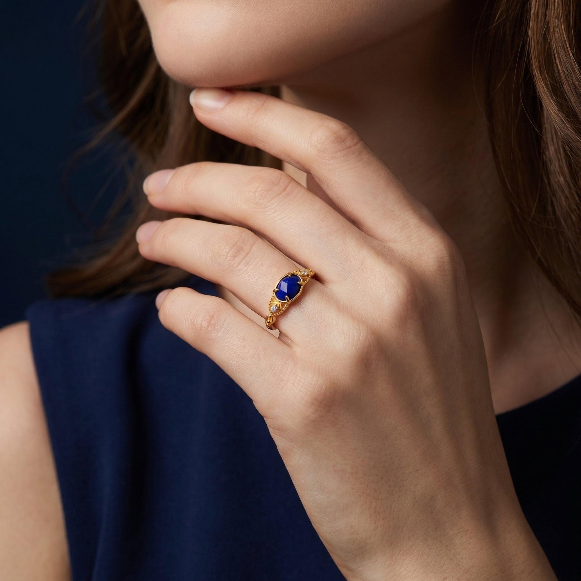 Model wearing the gold Elarissa ring with an oval lapis lazuli gemstone on her ring finger.