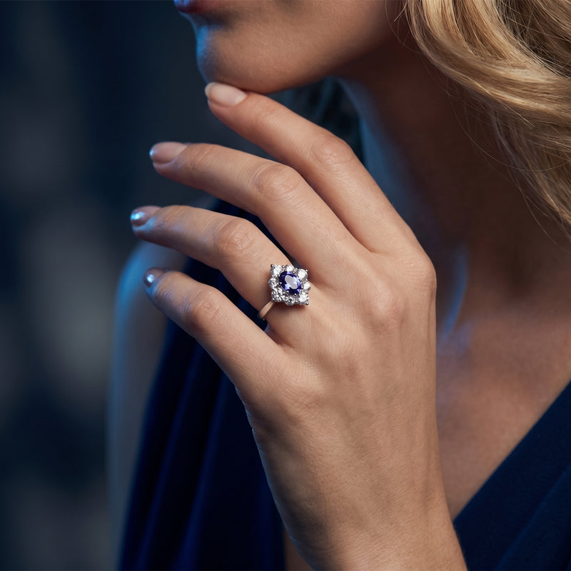 Model wearing the silver Lirienne ring on her finger, showing the oval tanzanite's blue-to-violet shift.