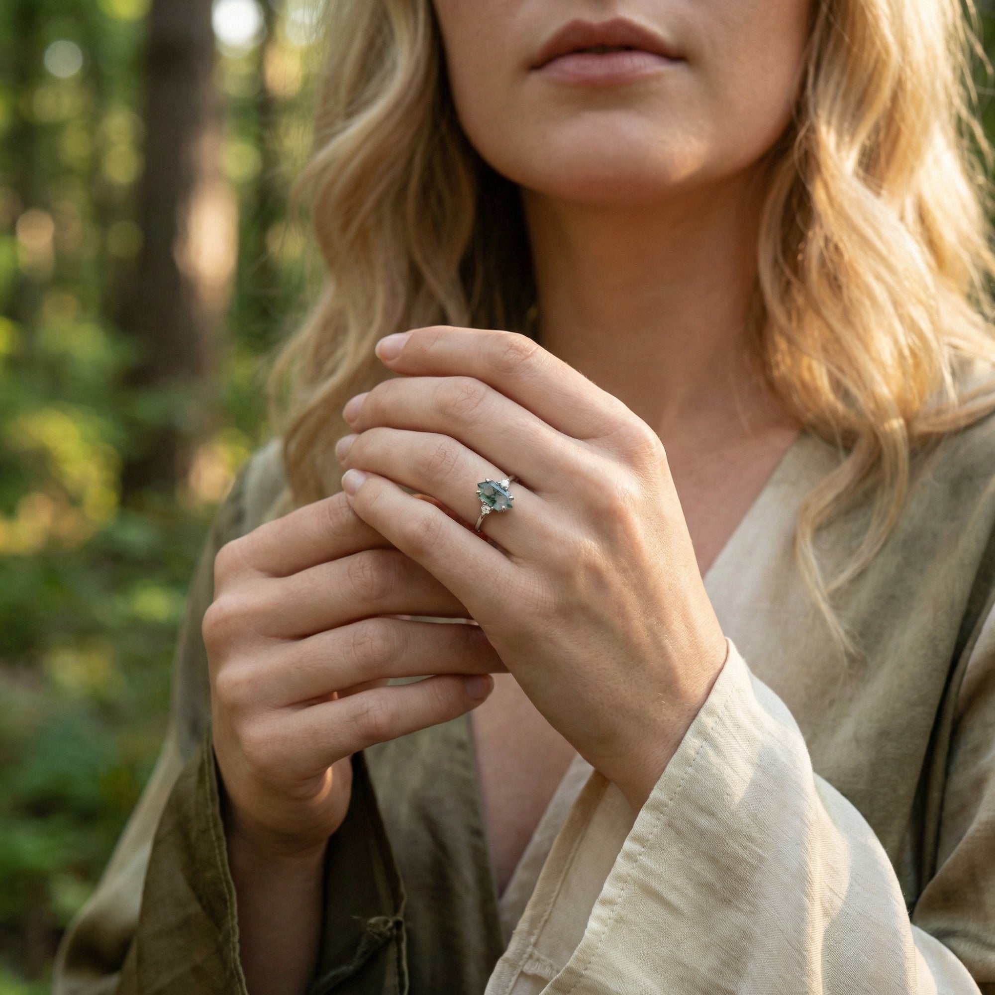 Model wearing the hexagon moss agate sterling silver ring on her finger in a natural forest setting.