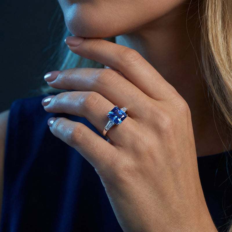 Woman wearing the princess-cut tanzanite and sterling silver ring on her ring finger.