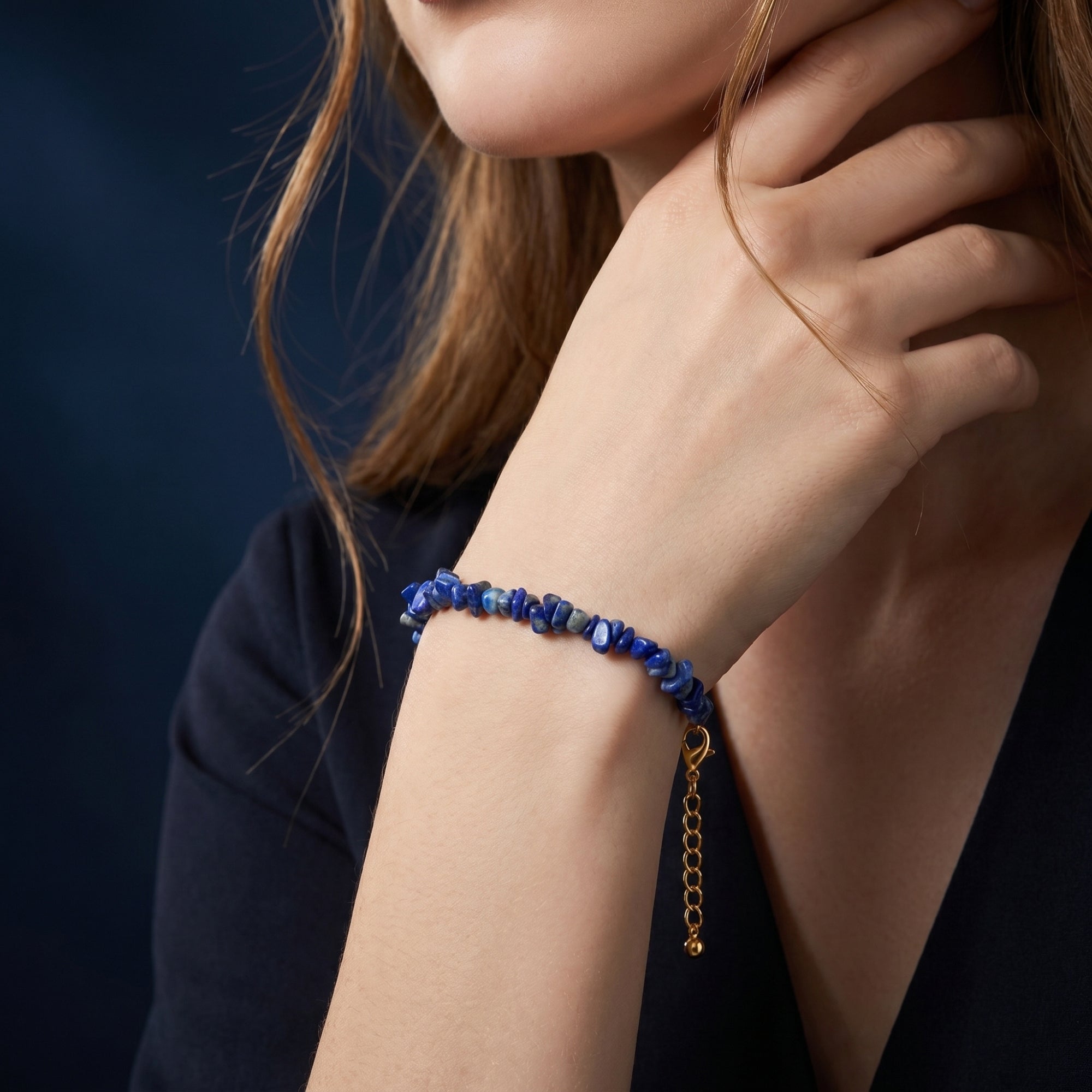 Midnight Pebble lapis lazuli bead bracelet with gold chain worn on a woman's wrist.