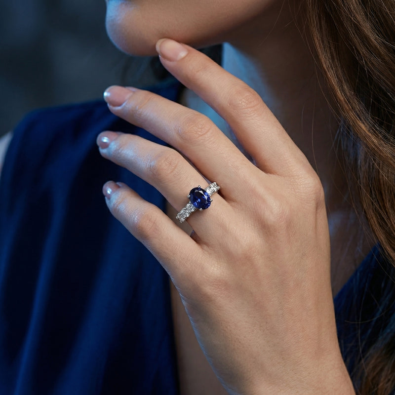 A woman wearing the Kaeliana oval tanzanite ring in sterling silver on her ring finger.