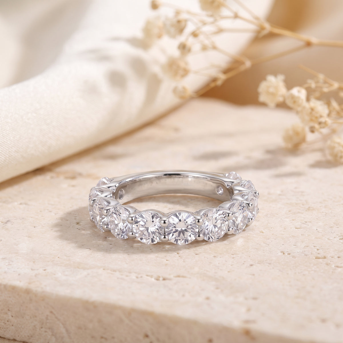 Front view of a silver eternity ring resting flat, showing its continuous row of round clear stones.