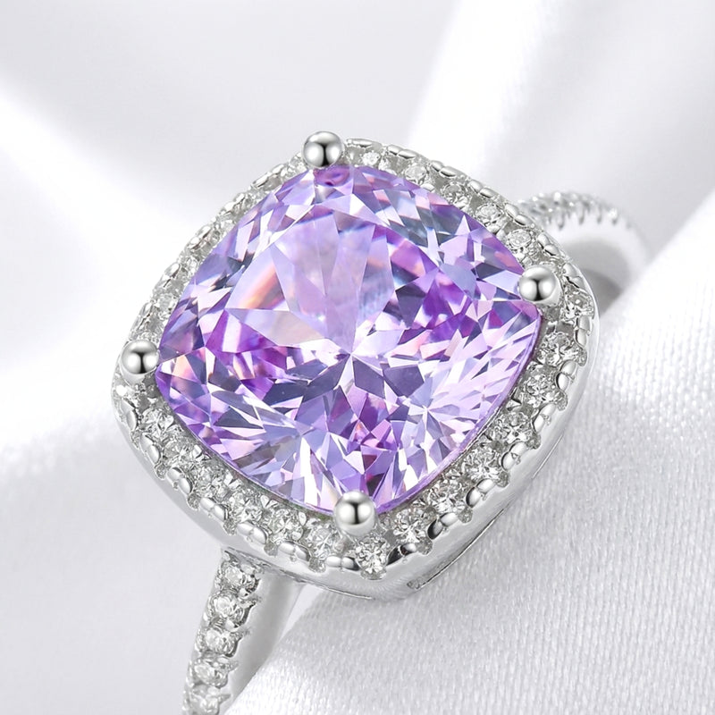 Macro view of the cushion cut purple simulated amethyst and halo setting on a sterling silver ring.