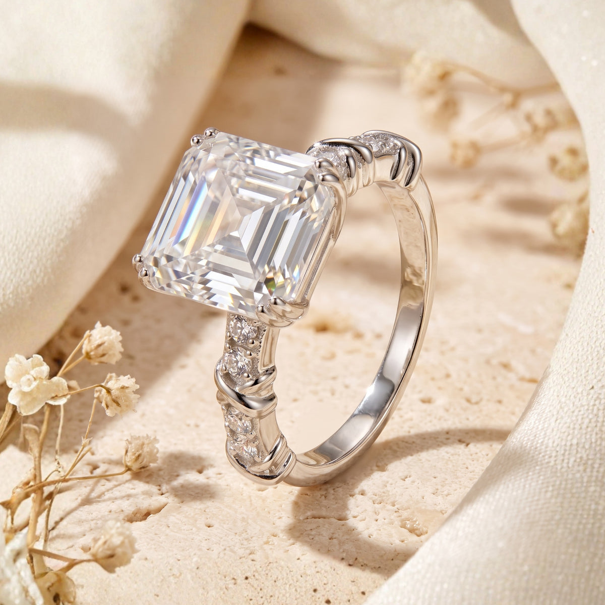 Close-up angled view of the silver ring showing its twisted accent band and prong-set rectangular emerald-cut stone.