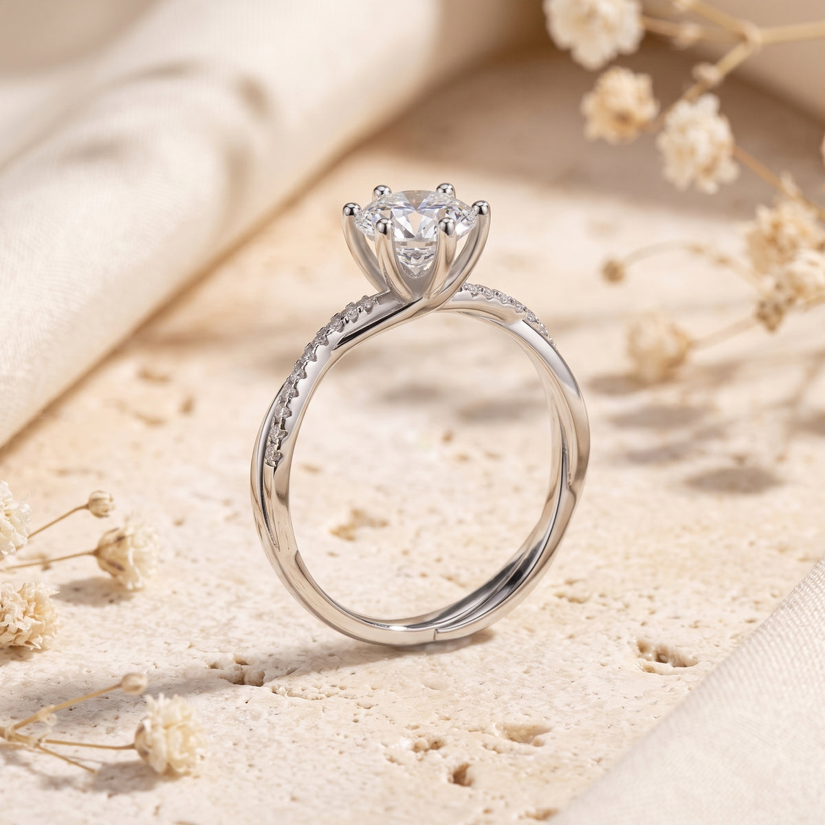 Rear upright view of a silver crossover ring showing its six-prong setting and pavé band details.