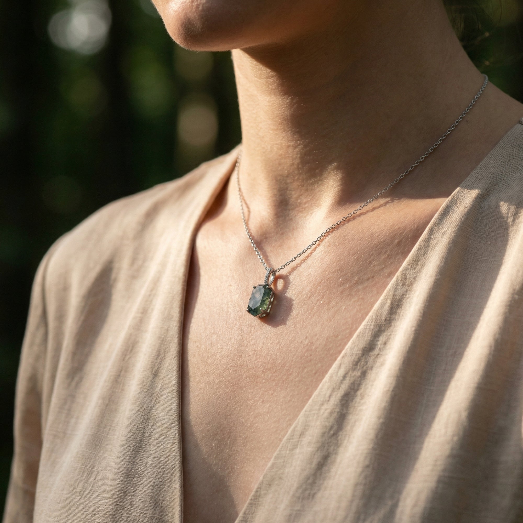 Side view of a model wearing the coffin cut moss agate column pendant necklace in sterling silver.