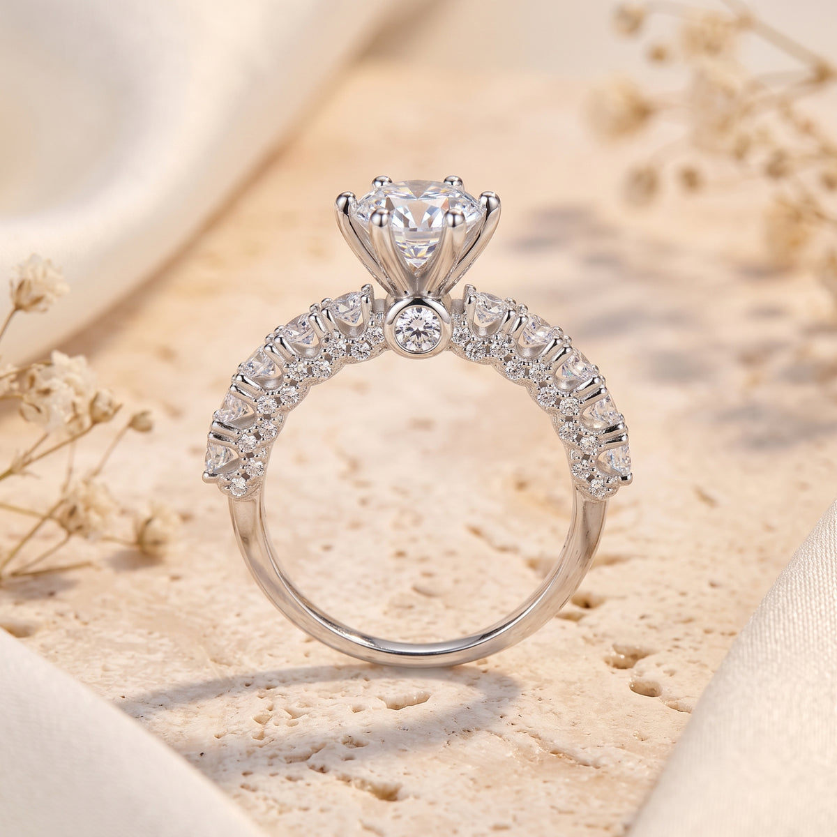 Close-up of silver cathedral ring showing six-prong crown setting and side stones.