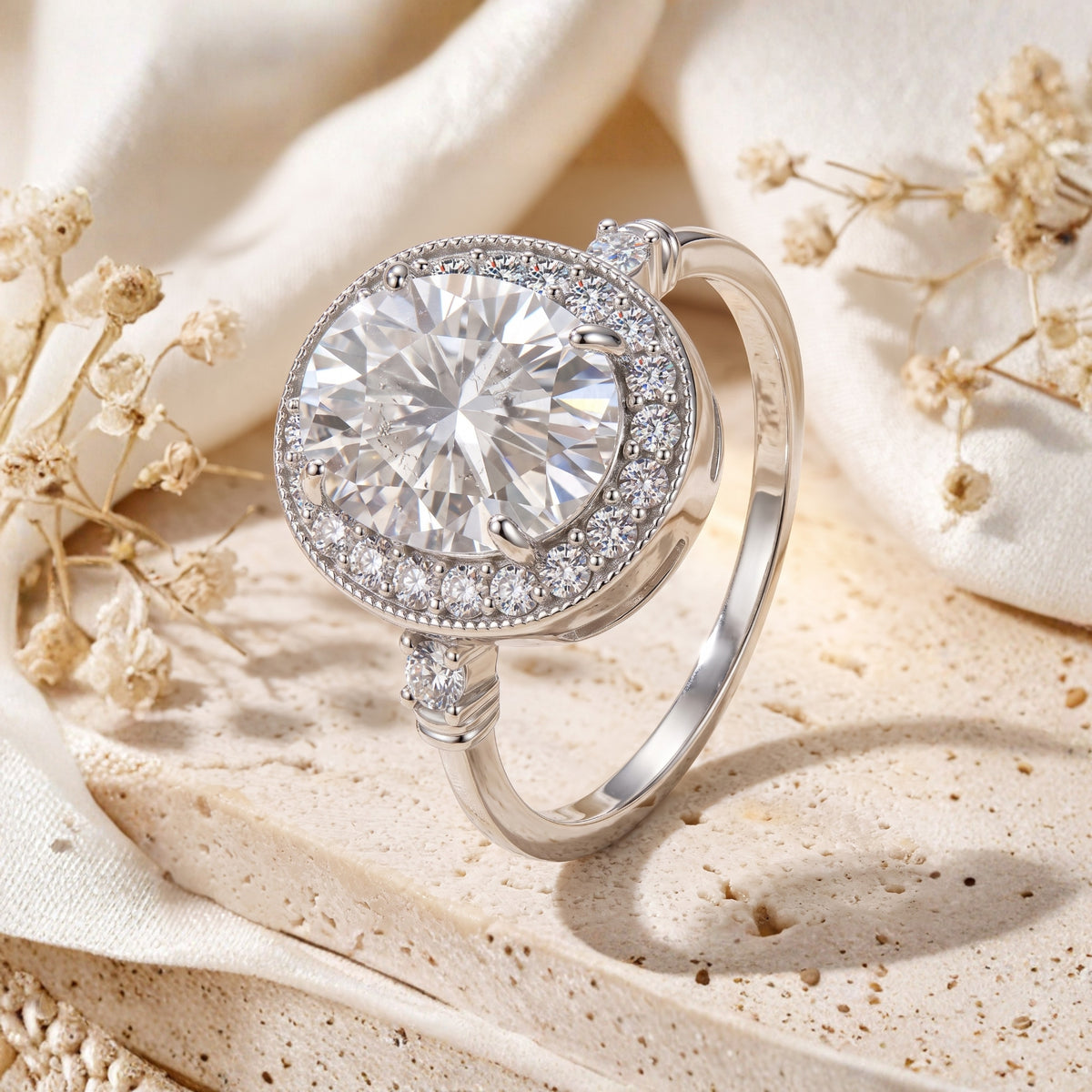 Angled view of the silver oval halo ring, showing its raised setting, side stones, and smooth band.