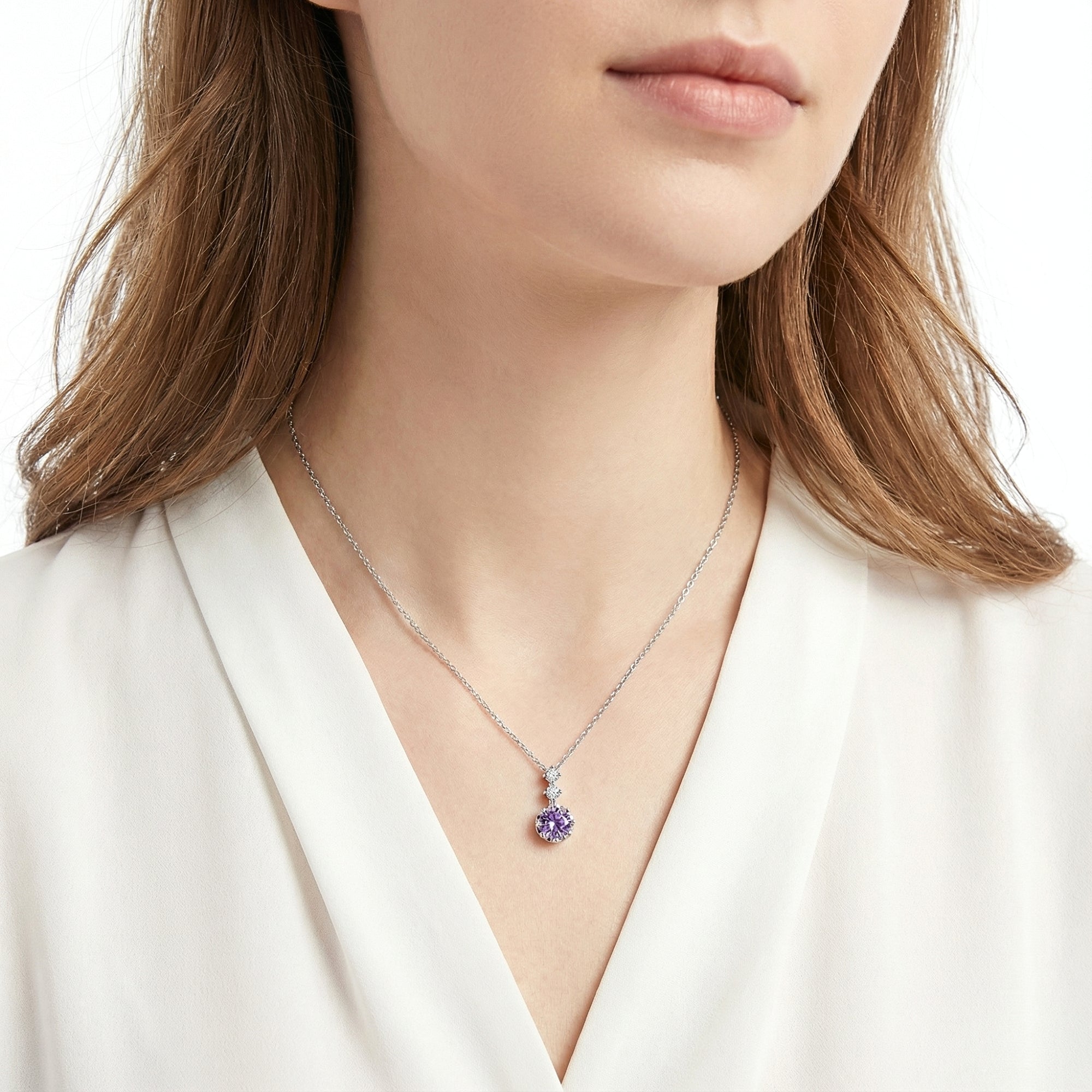 Model wearing the Serenidad sterling silver necklace with a round purple simulated amethyst pendant.