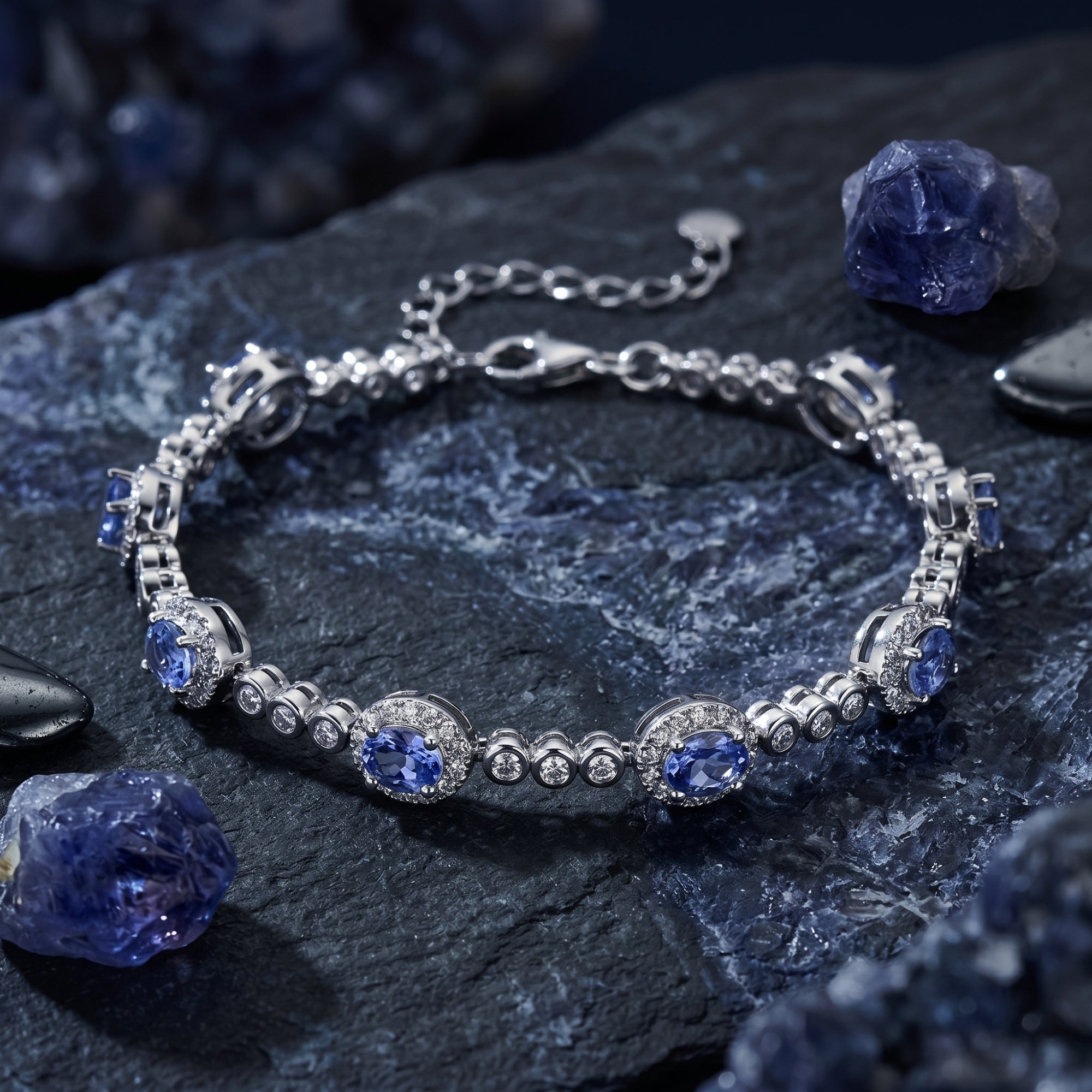 Macro view of the oval natural tanzanite stones and halo settings on a sterling silver line bracelet.