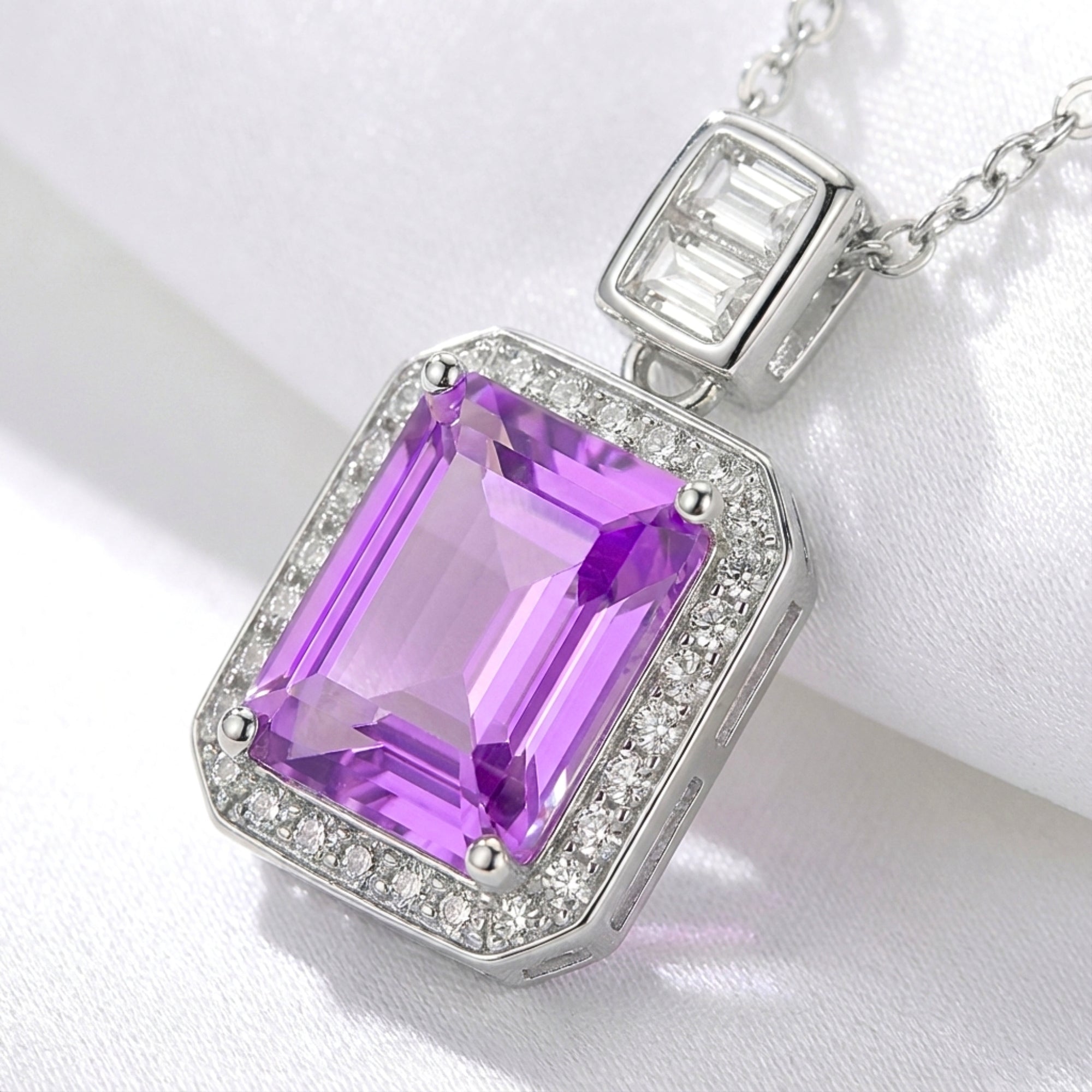 Close-up of an emerald cut purple simulated amethyst pendant with a halo setting in sterling silver.