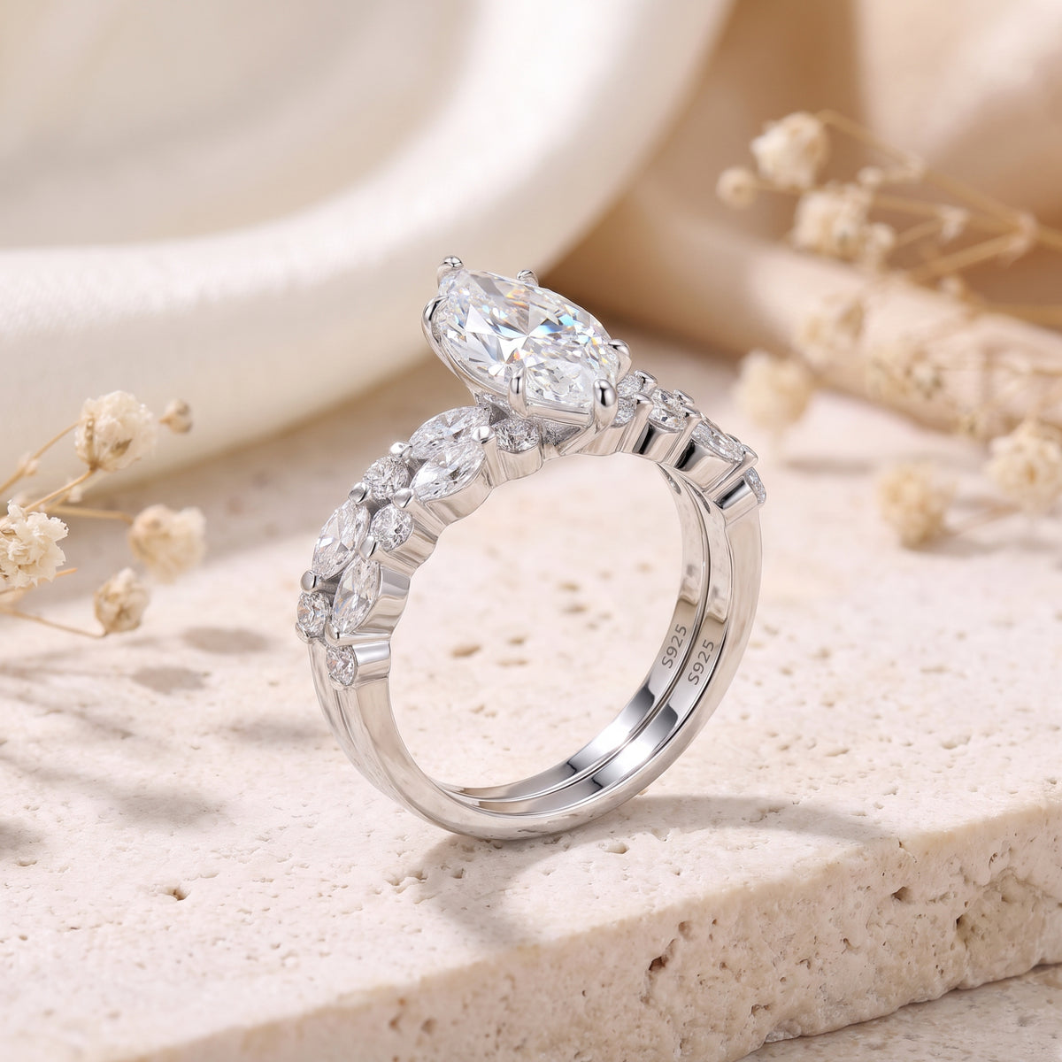 Side view of a stacked silver ring set showing the elevated marquise setting and S925 stamps inside the bands.