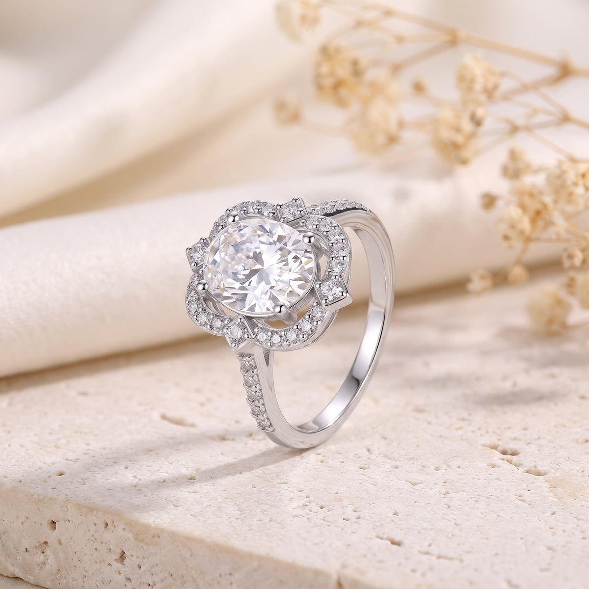 Side-angled perspective of the silver scalloped halo ring standing on a stone surface.