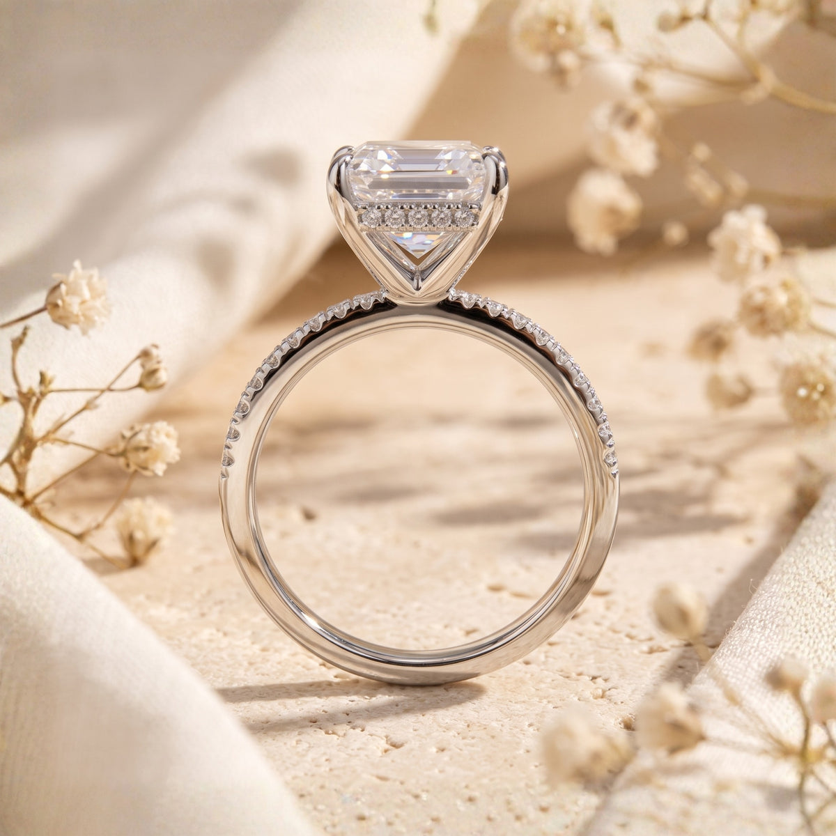 Rear view of the silver ring showing the hidden halo beneath the emerald-cut stone and pavé band.