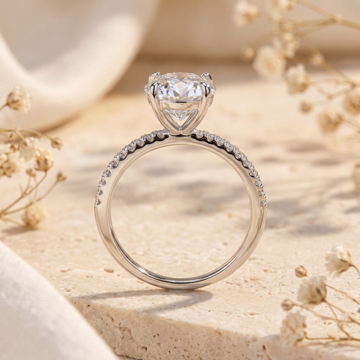 Rear view of the silver ring showing its cathedral gallery setting and pavé-set band on a stone surface.