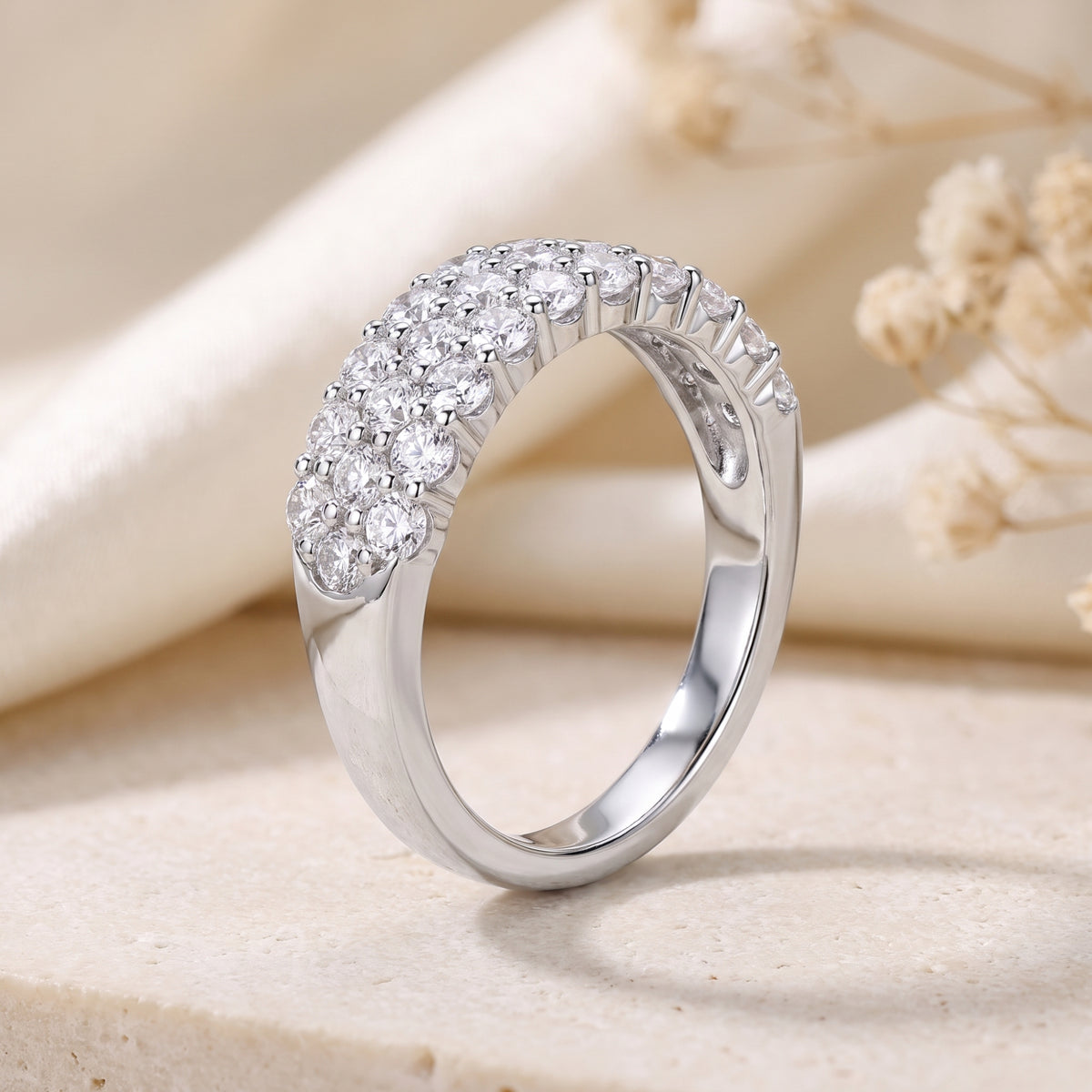 Profile view of a three-row round cubic zirconia pavé ring in sterling silver.