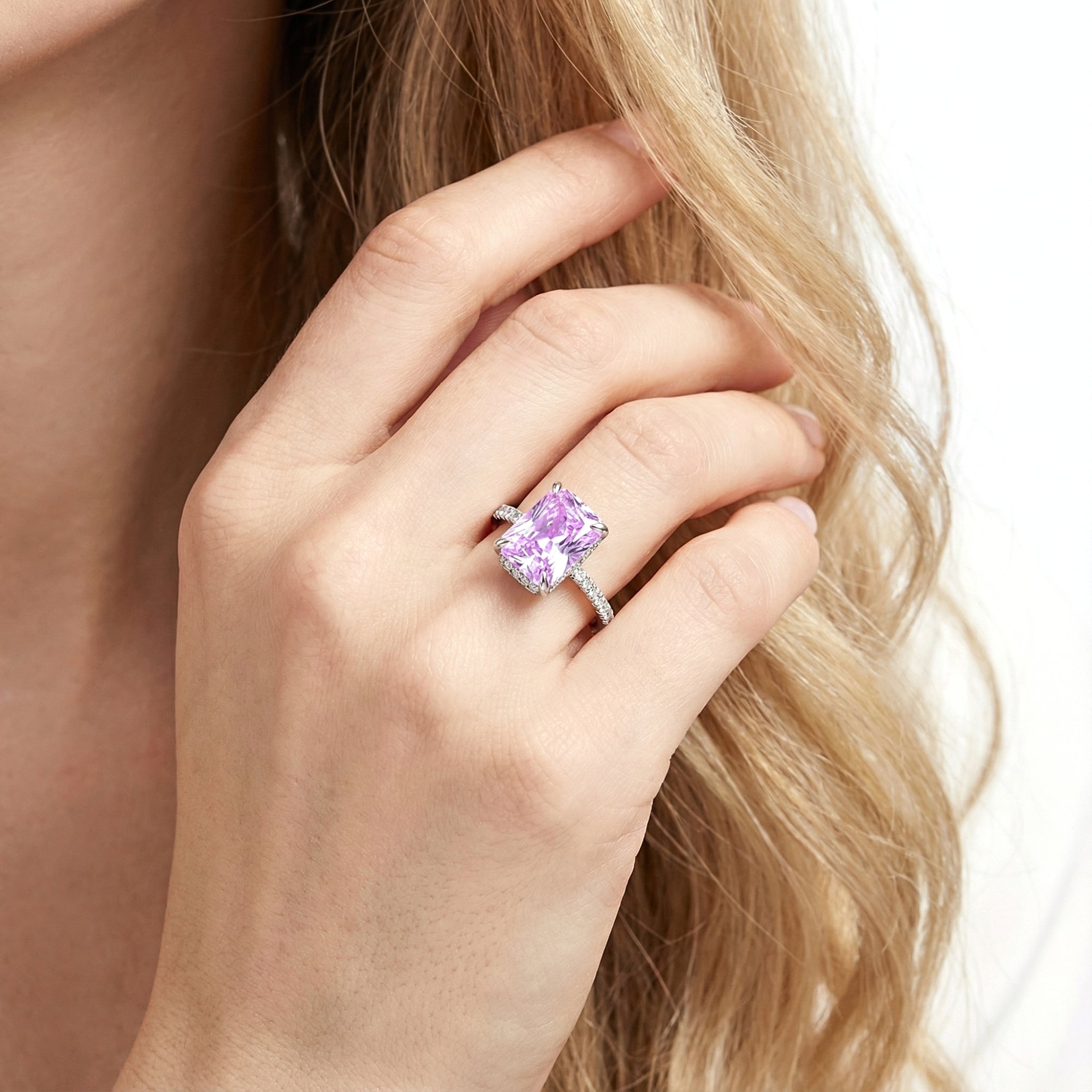 Radiant cut purple simulated amethyst ring in sterling silver worn on a woman's hand.