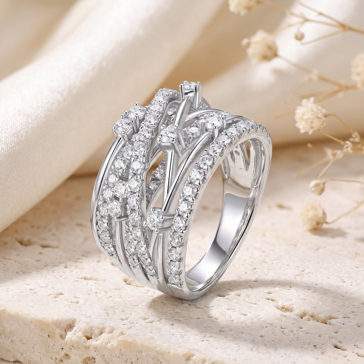 Front-angled macro view of interlaced silver bands and prong-set clear stones on the ring.
