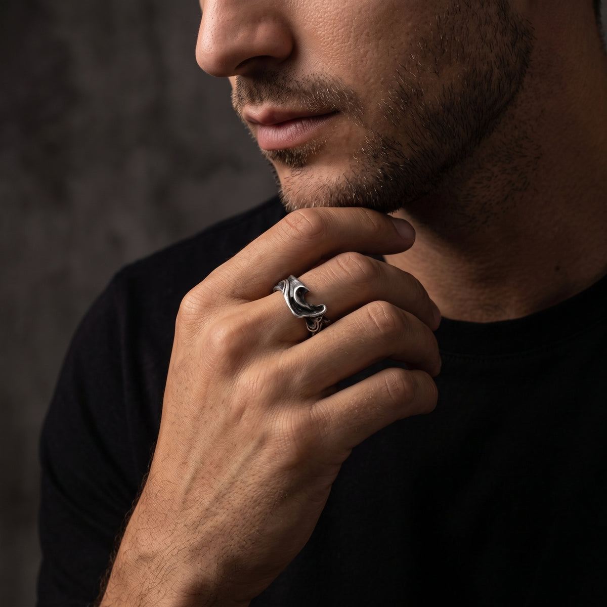 Close-up portrait of a man wearing the textured silver wave open ring beneath his chin.