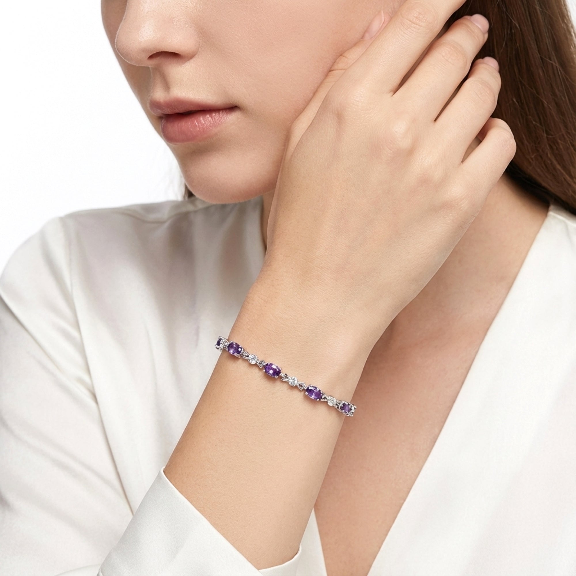 Model wearing the Valeriane sterling silver bracelet with oval simulated amethyst stones and a white blouse.
