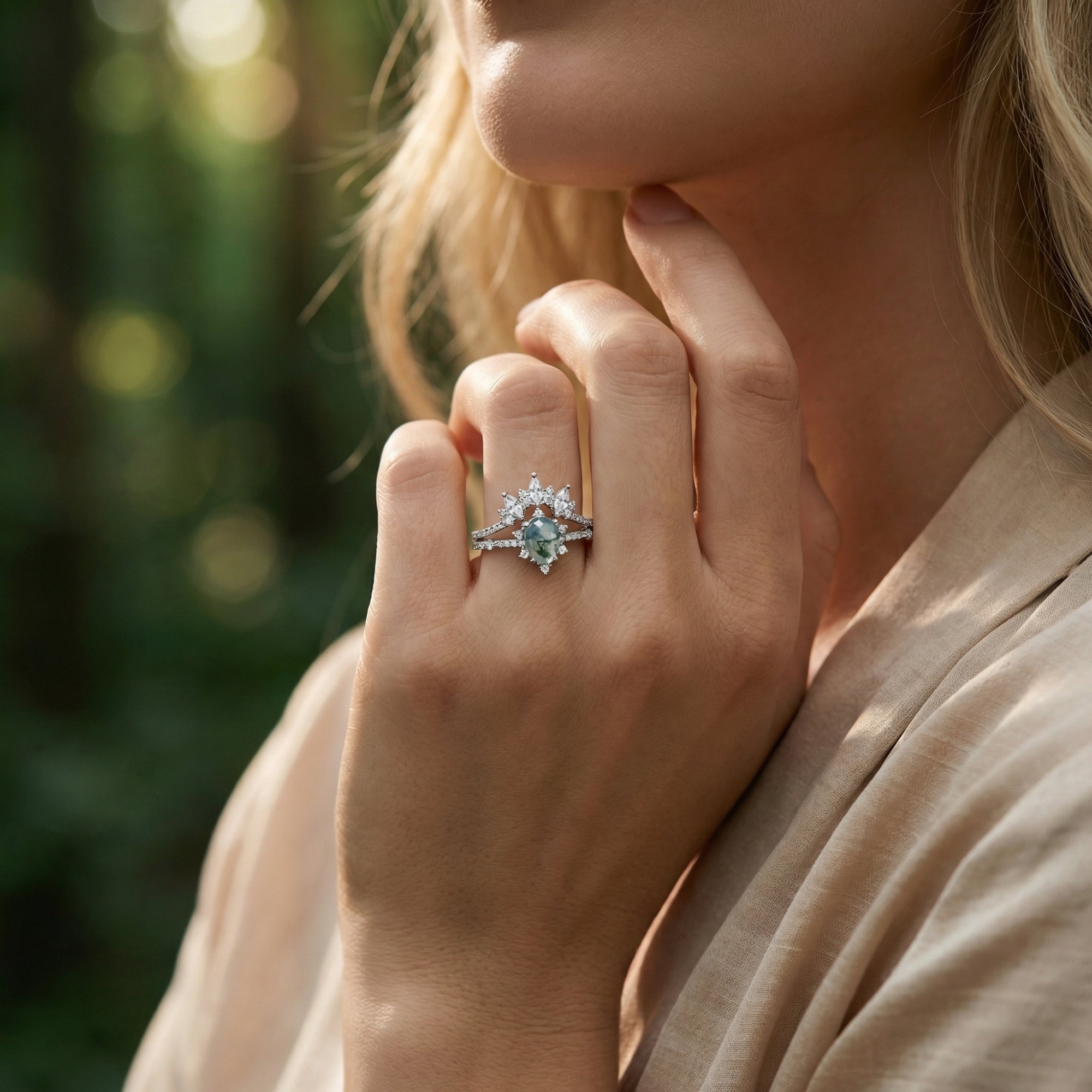 Silver ring set with frosted kite cut moss agate and marquise diamonds worn on a woman's hand.