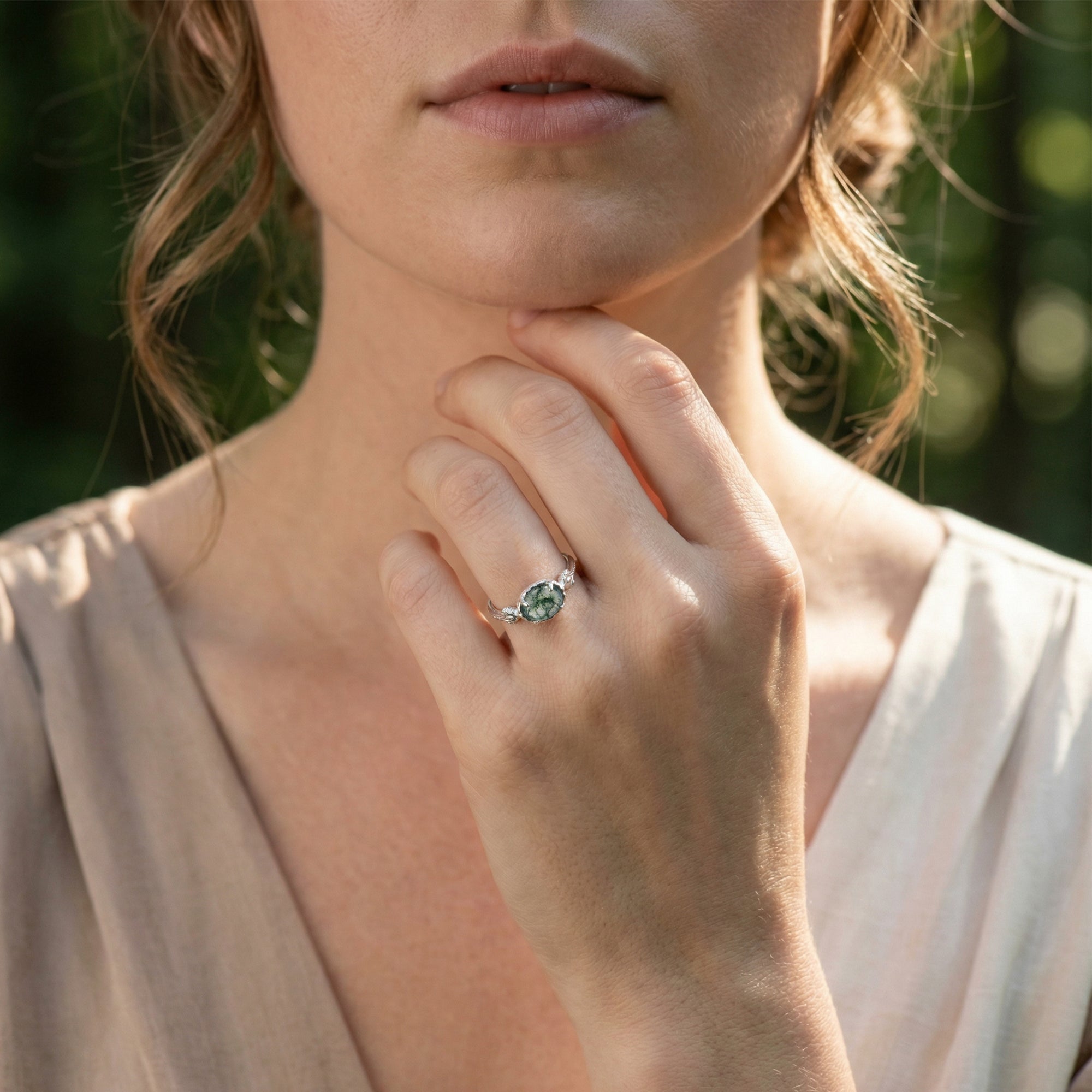Model wearing the oval natural moss agate sterling silver ring, showcasing its size and appearance on the hand.