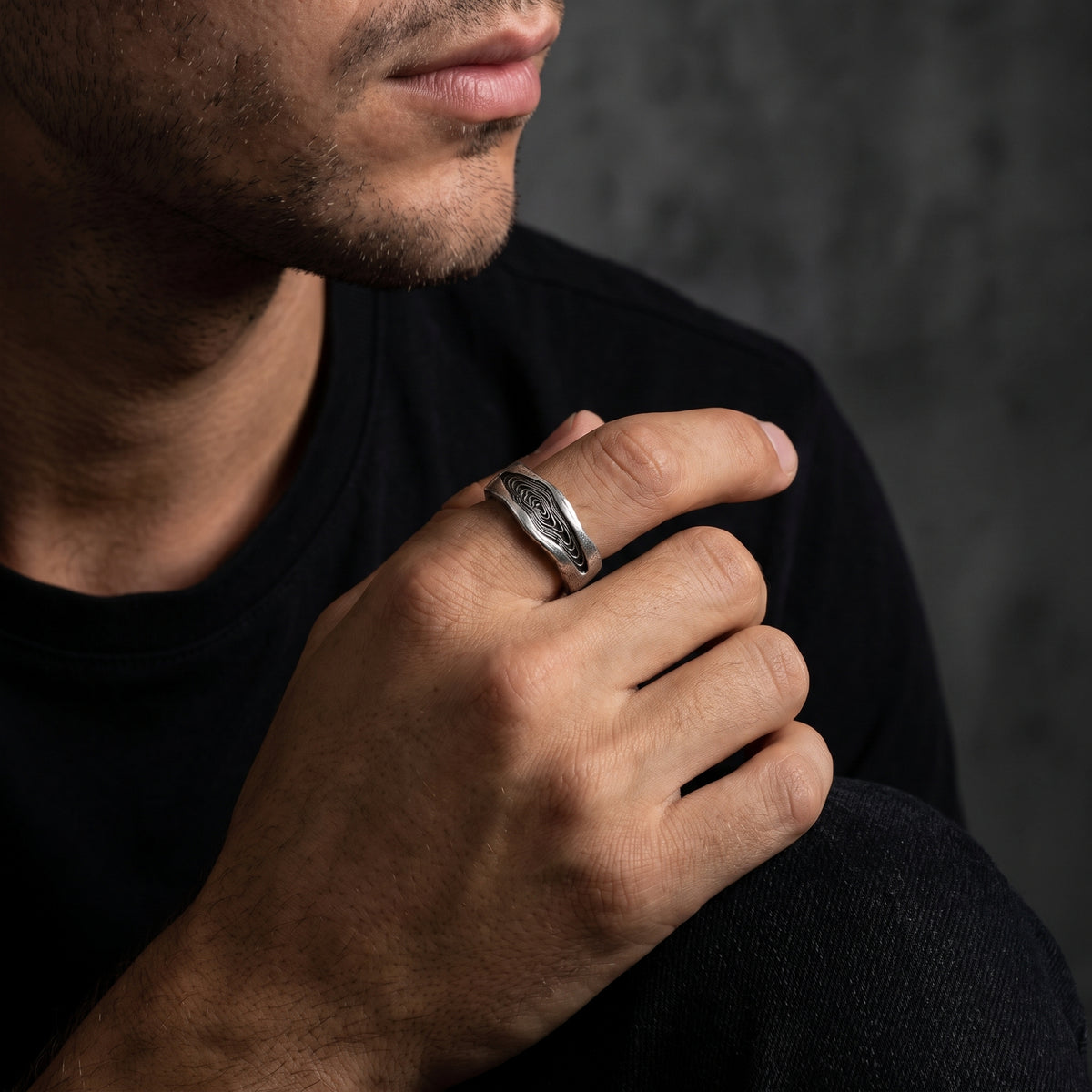 Man wearing the silver wood grain ring on his index finger in a relaxed pose.