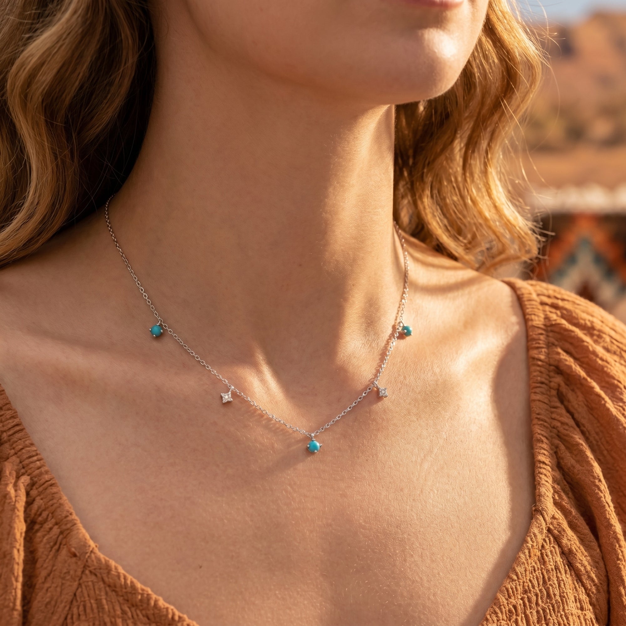 Model wearing the Southwestern-inspired silver turquoise necklace with delicate star charms and blue beads.