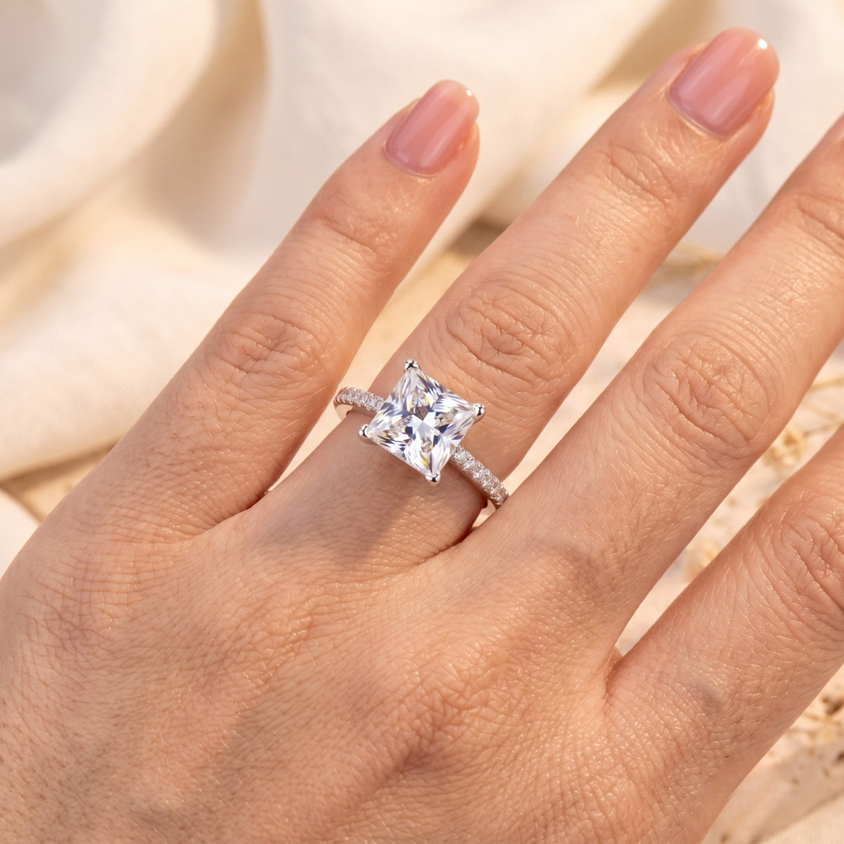 Close-up of a hand showcasing the 14K or 18K solid gold princess-cut ring with light catching the square natural zircon center stone.