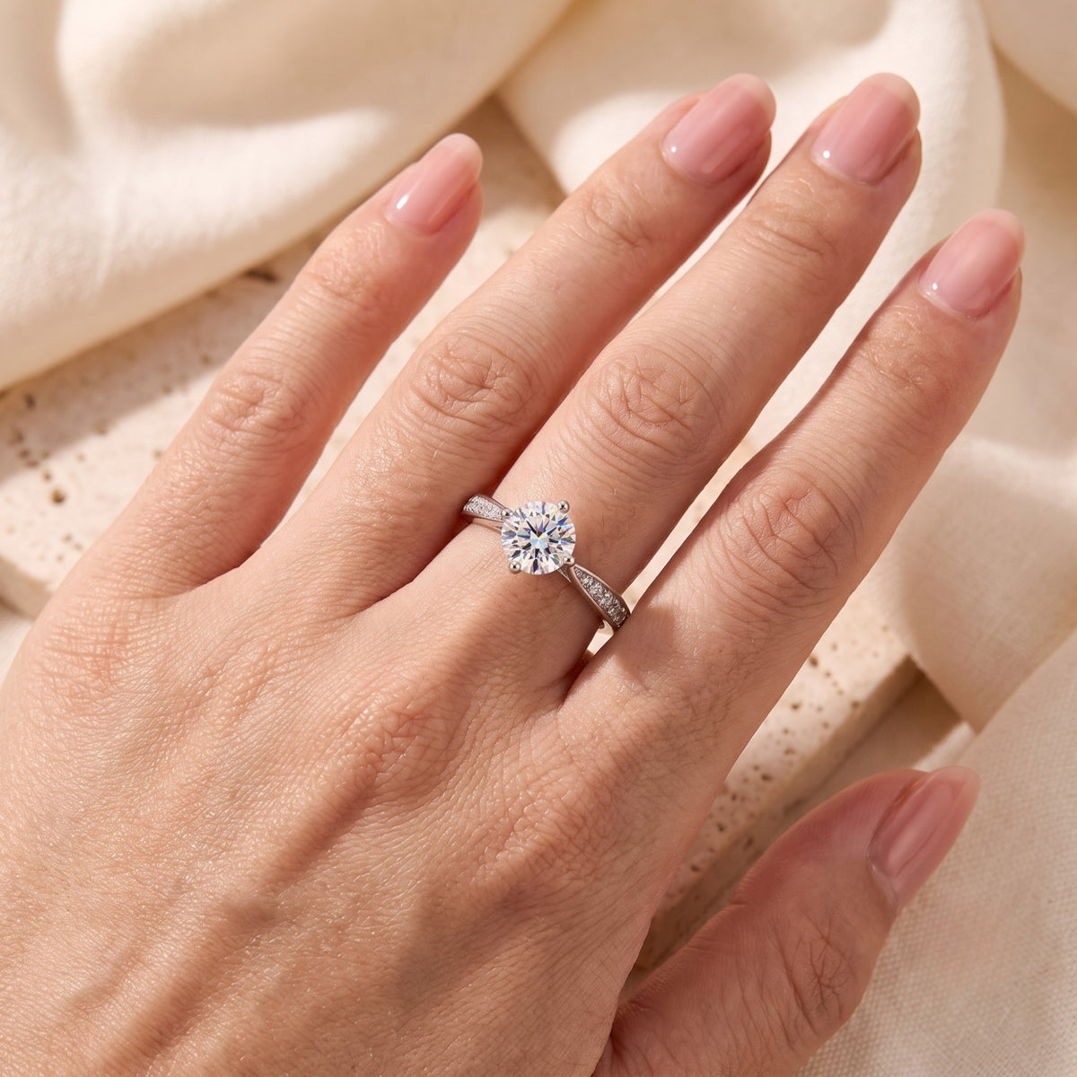 Top view of the sterling silver round cut micro-pavé solitaire ring on a model's hand to show scale and fit.