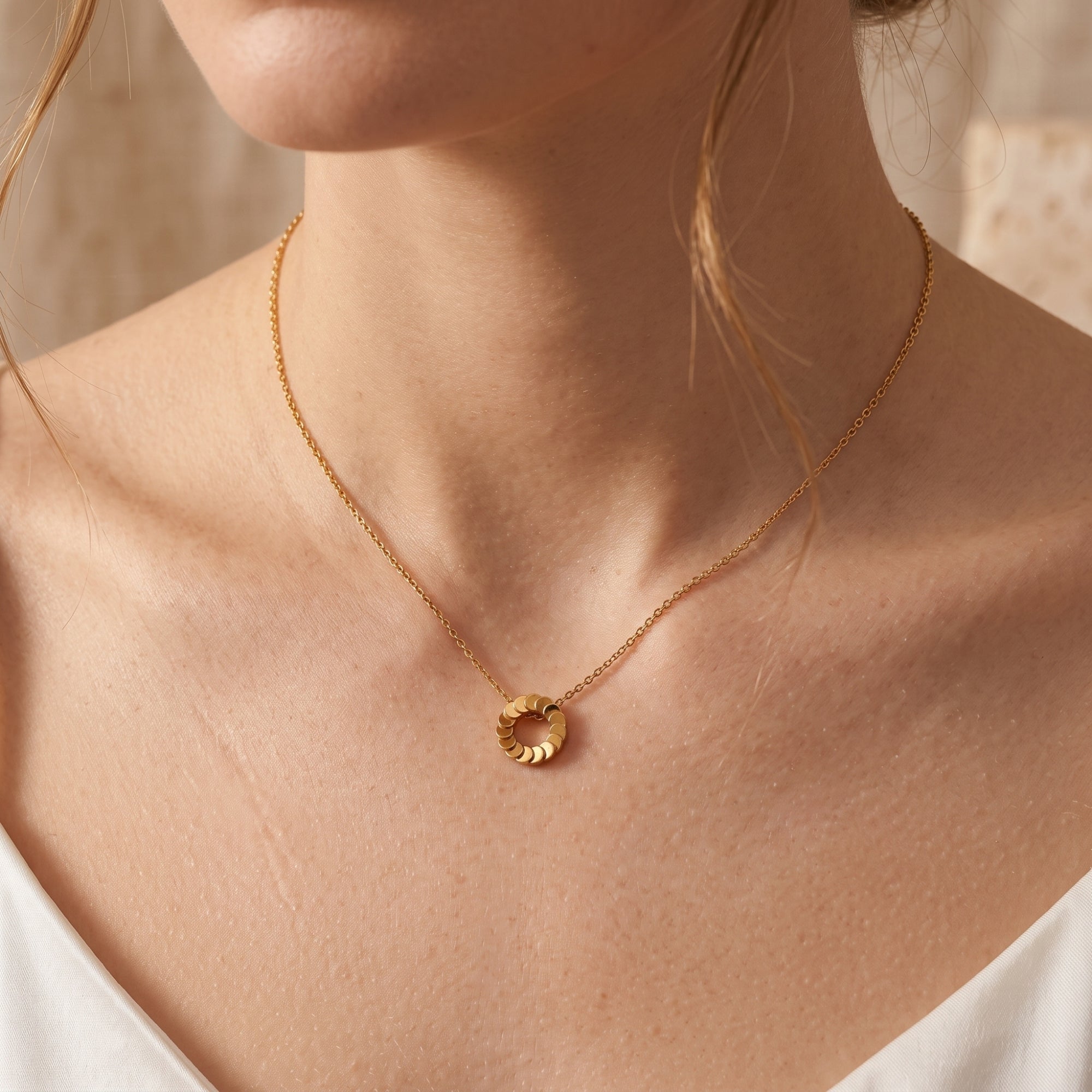 Front view of the Freya 18K gold plated necklace on a model's neck.