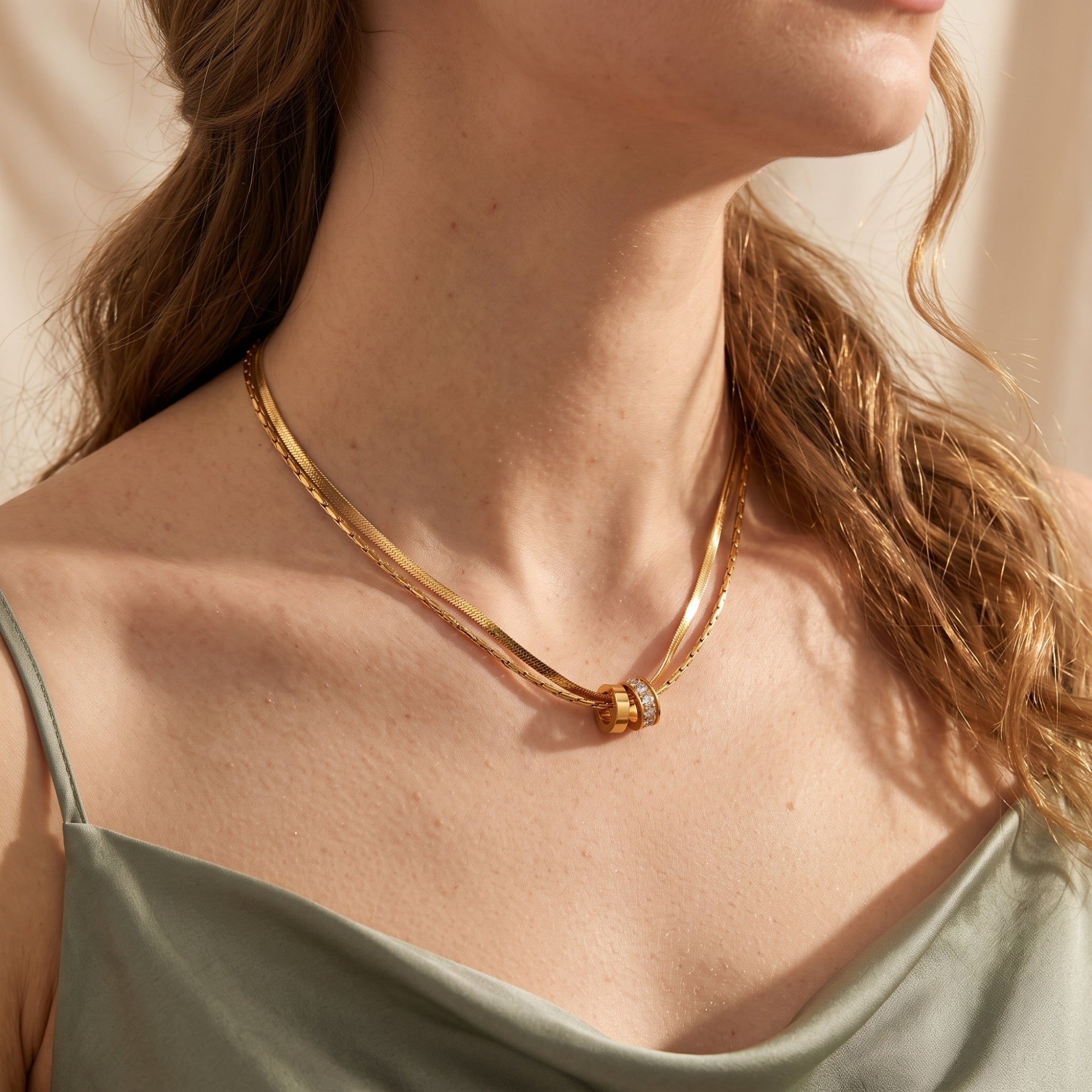 Model wearing a double-layered gold necklace with interlocking rings and CZ stones.