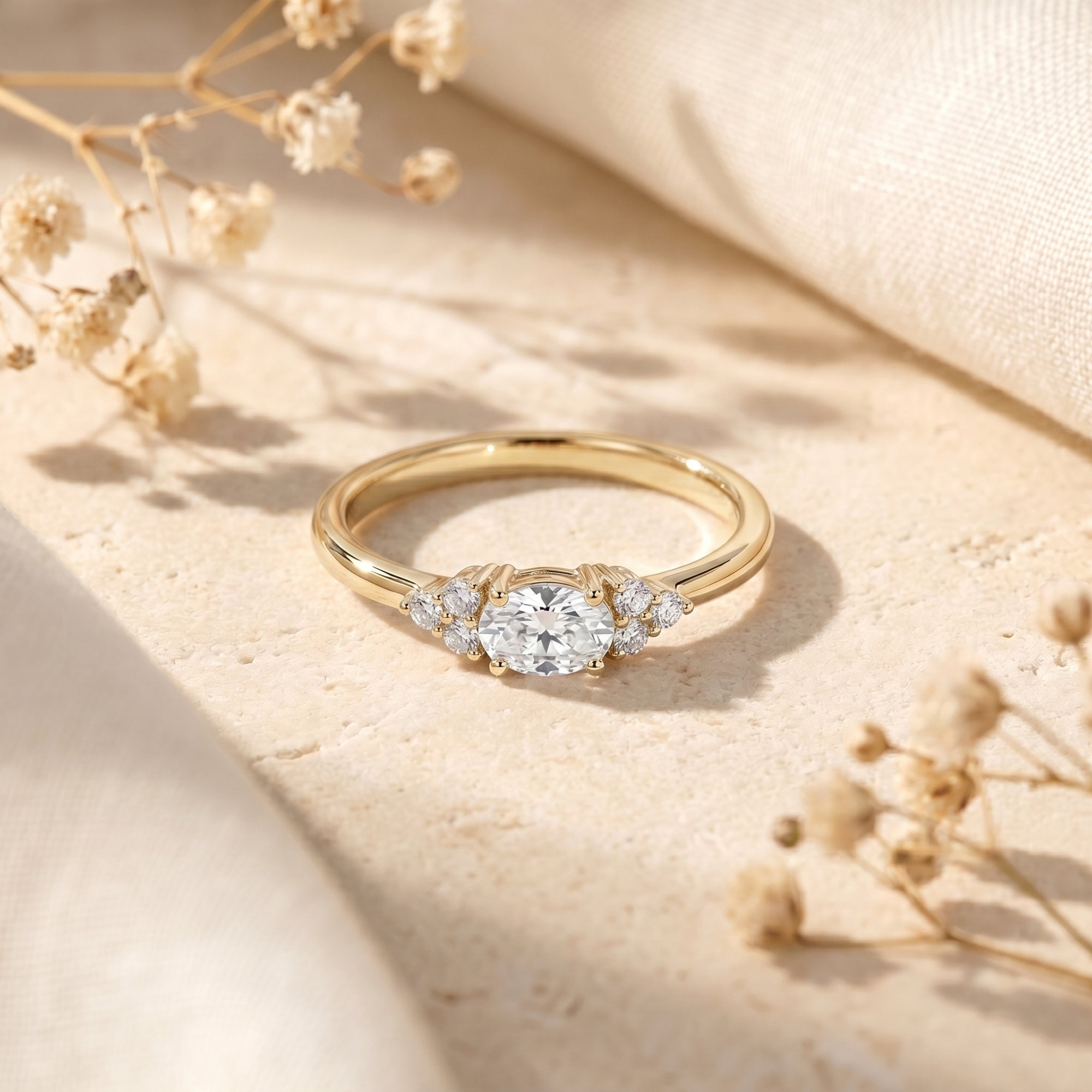 Yellow gold oval moissanite engagement ring on a textured stone background.