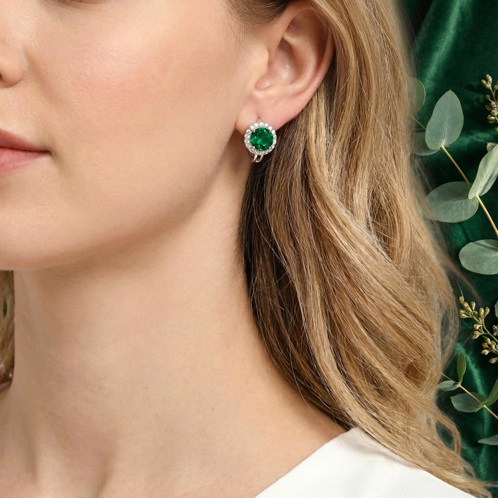 Green moissanite halo earring in sterling silver worn on a model's ear against a green lifestyle backdrop.
