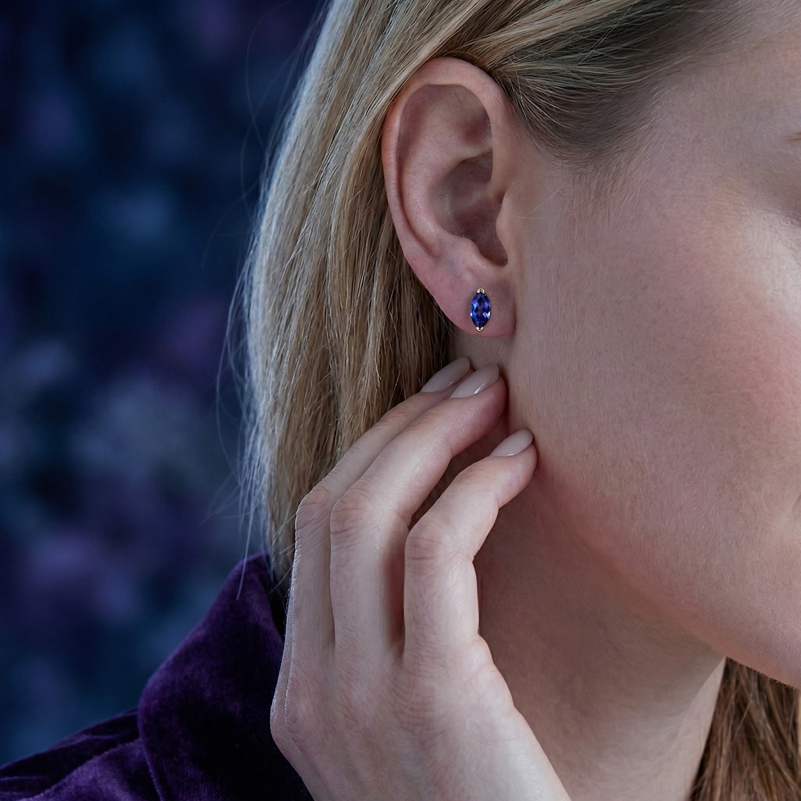 Side profile of a woman wearing a marquise simulated tanzanite earring in 18K gold vermeil.