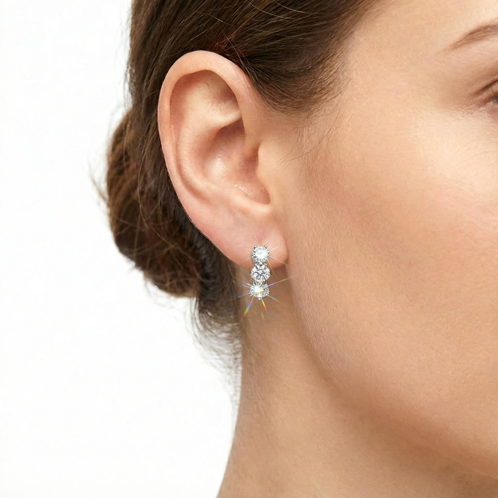 Close-up of a woman wearing the S925 sterling silver trio huggie earring with round-cut simulated diamonds.