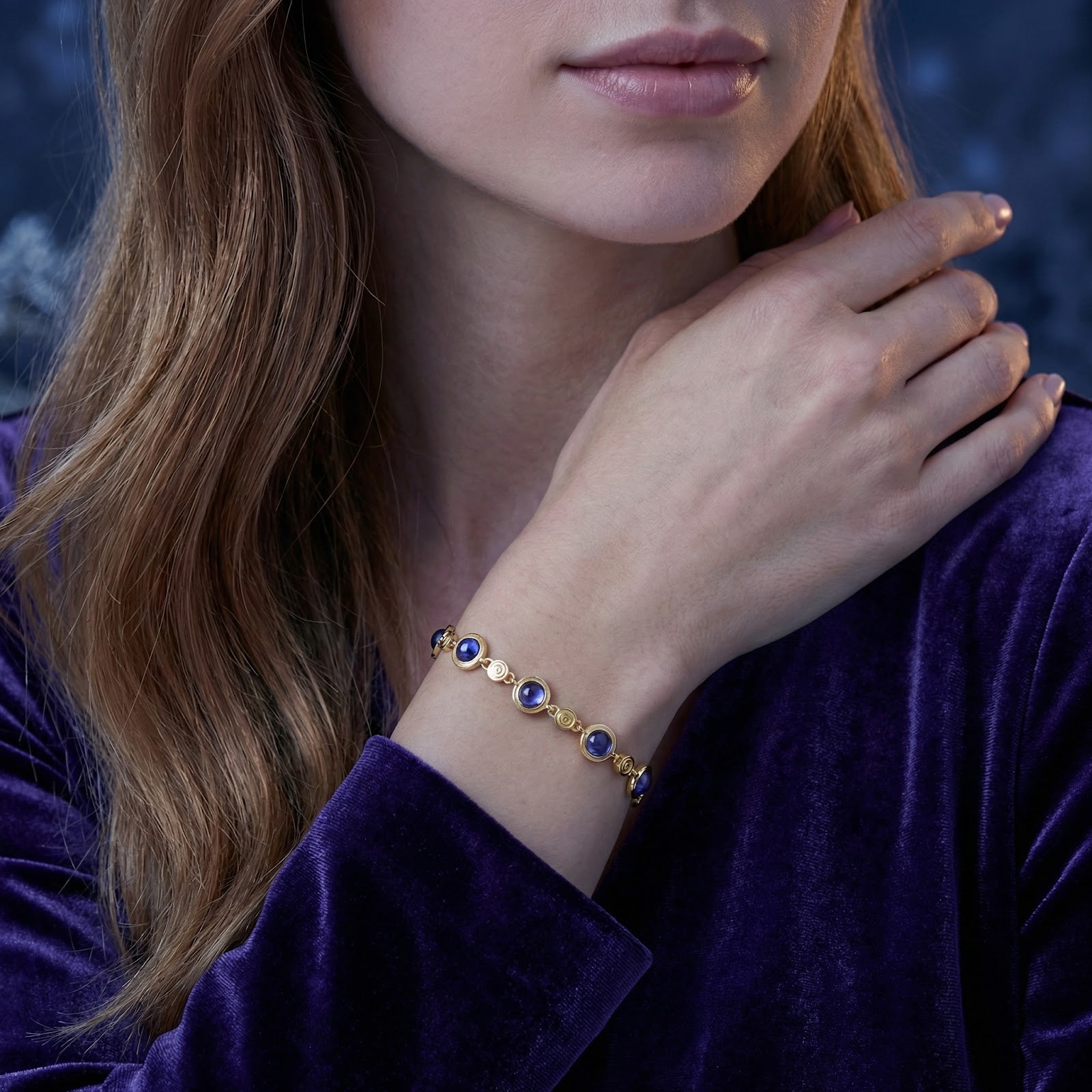 Model wearing the 18K gold vermeil Verielle station bracelet featuring round blue-violet simulated tanzanite.