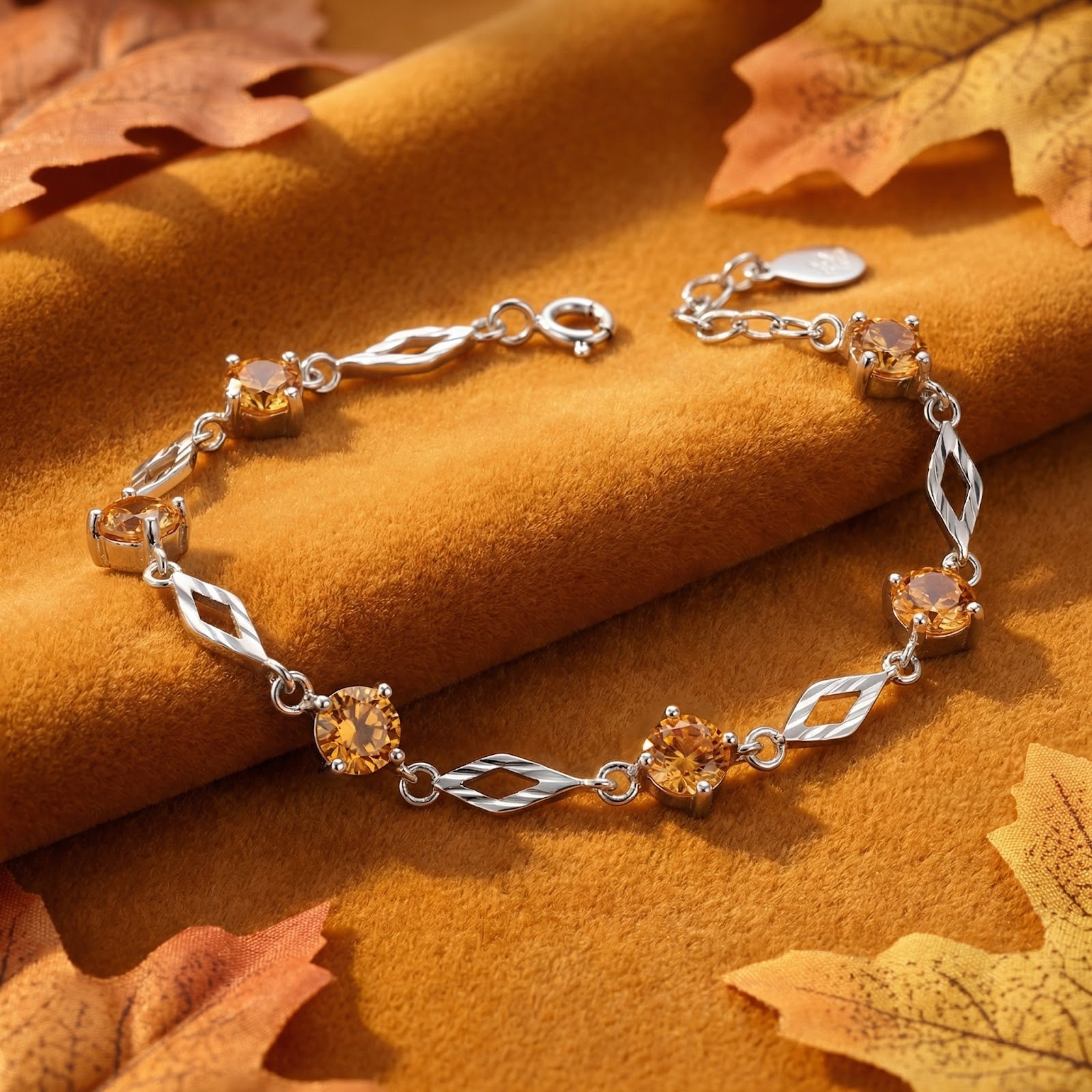 S925 sterling silver station bracelet with honey-colored simulated topaz stones and diamond-shaped links on velvet.