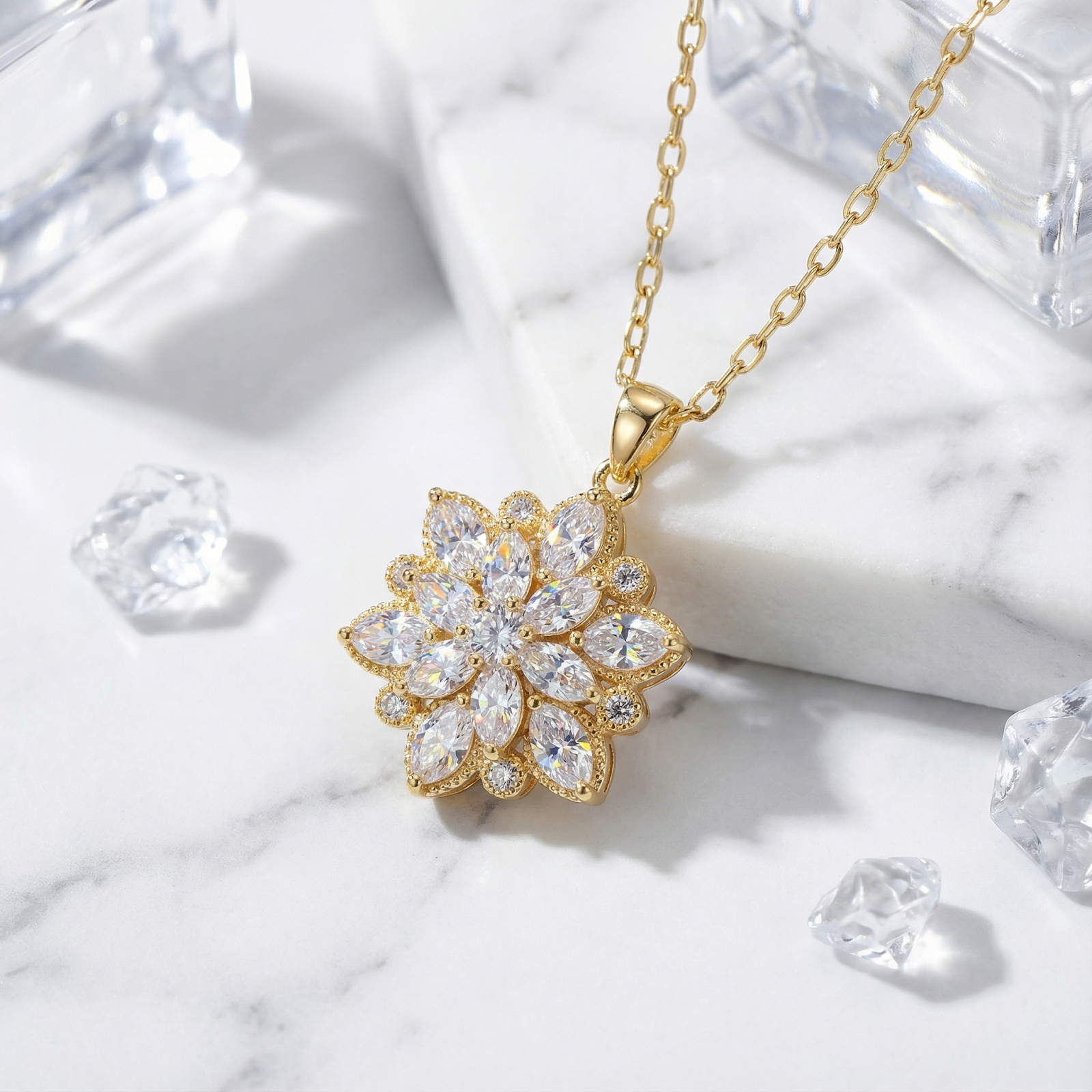 Close-up of a gold stainless steel floral pendant with marquise-cut simulated diamonds on marble.
