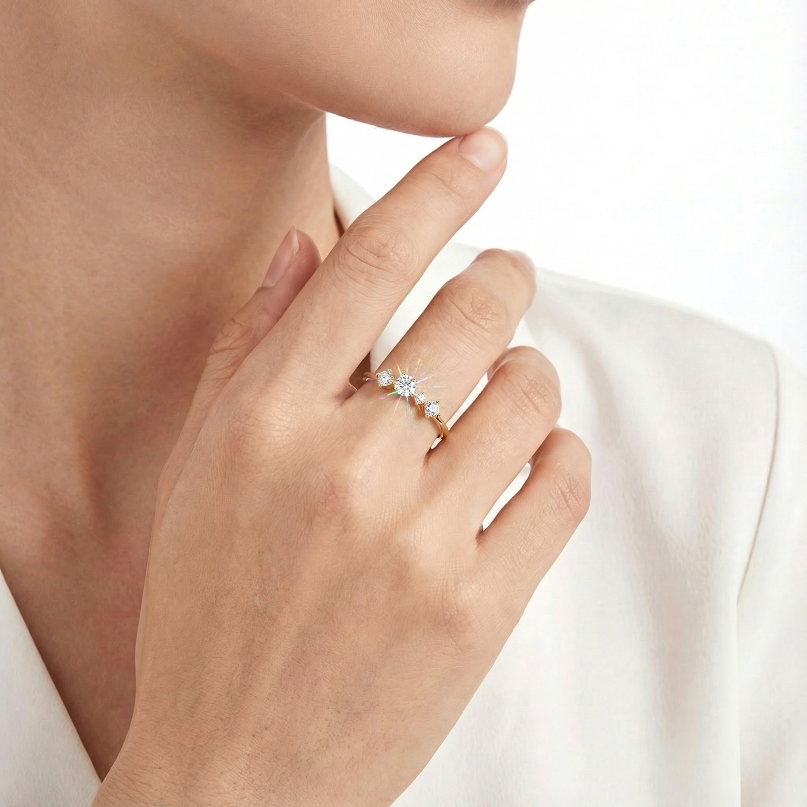 18K gold vermeil Elysian Orbit ring with moissanite stones worn on a model's hand against a cream sweater.