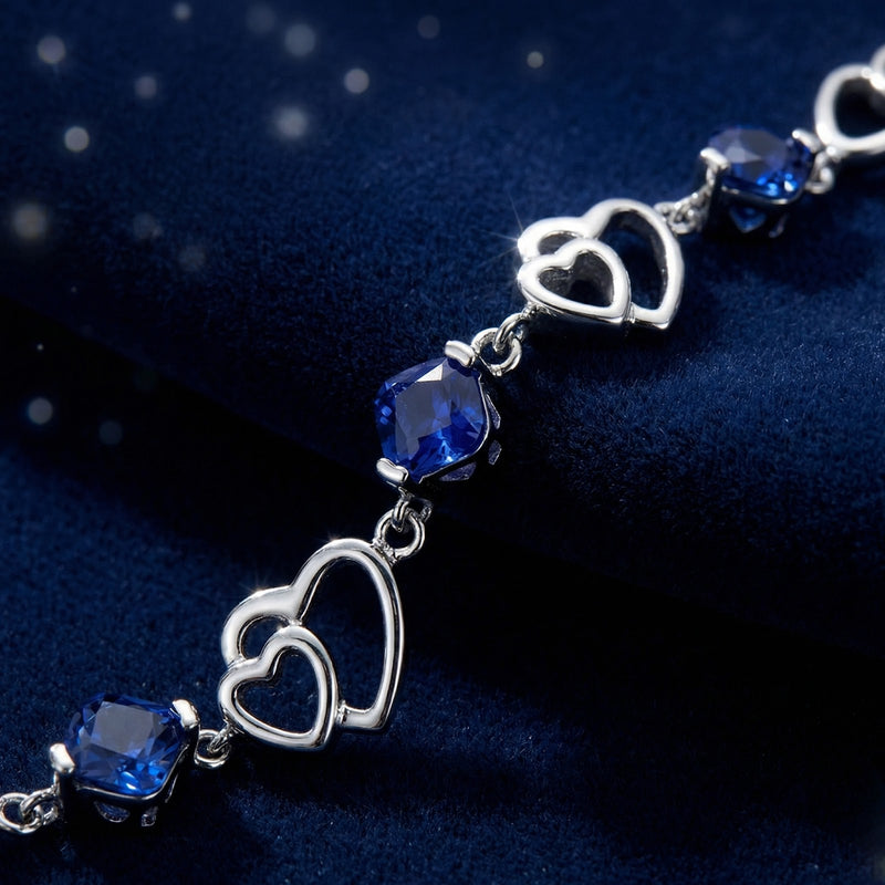 Close-up of S925 sterling silver heart links and precision-cut square royal blue simulated sapphires.